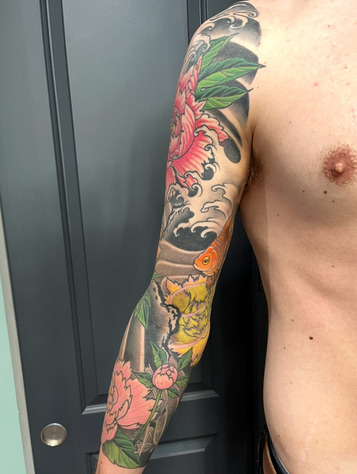 Peony and koi japanese irezumi tattoo on the upper arm by Miles Maniaci, Chicago, Illinois