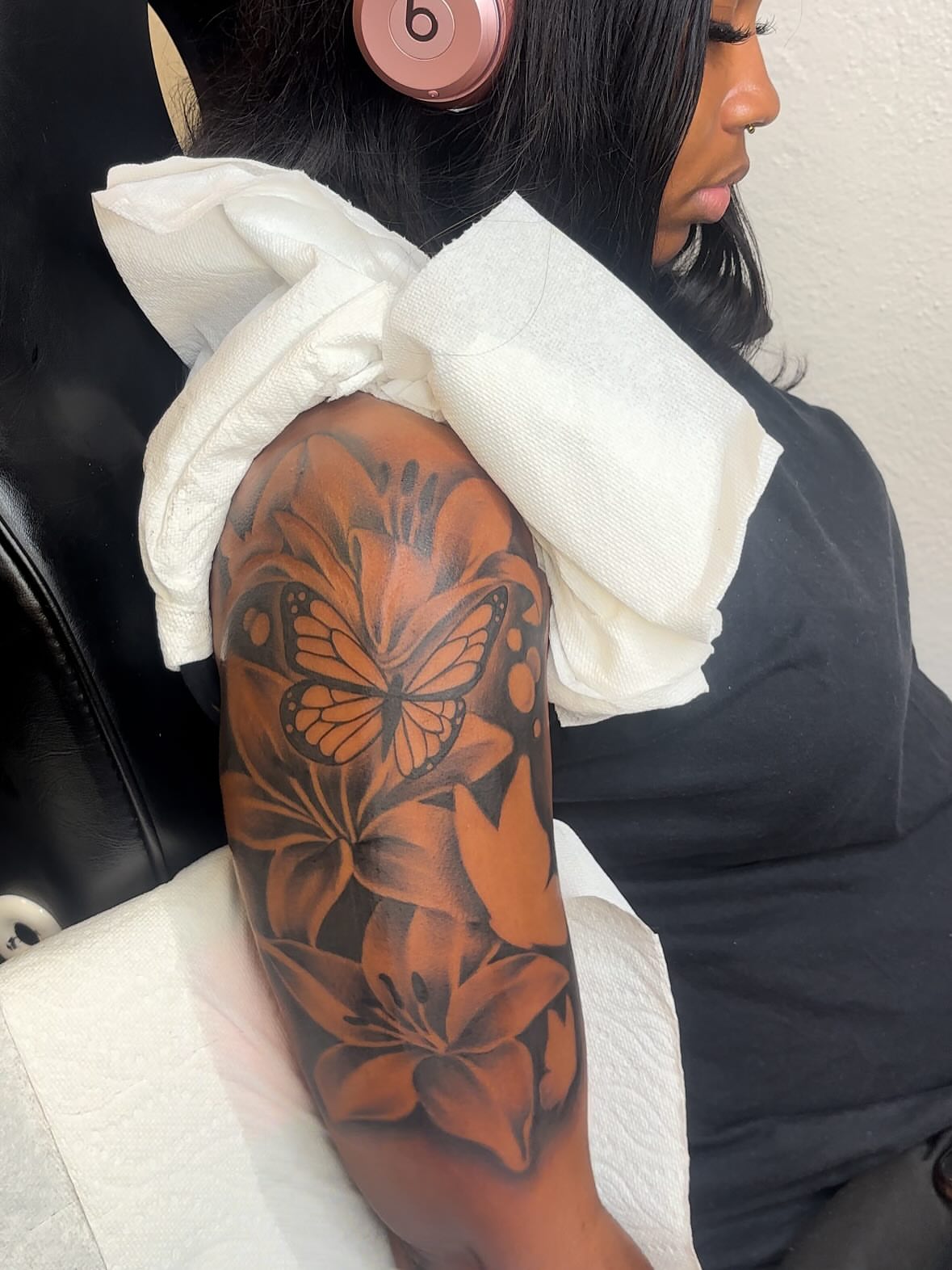 Butterfly and flowers black and grey tattoo on the upper arm by FleeDott 🇨🇴