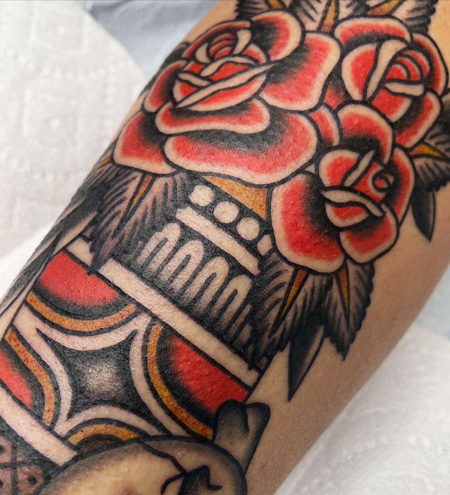Roses and building American traditional tattoo on the forearm by Kat, Sacramento, California