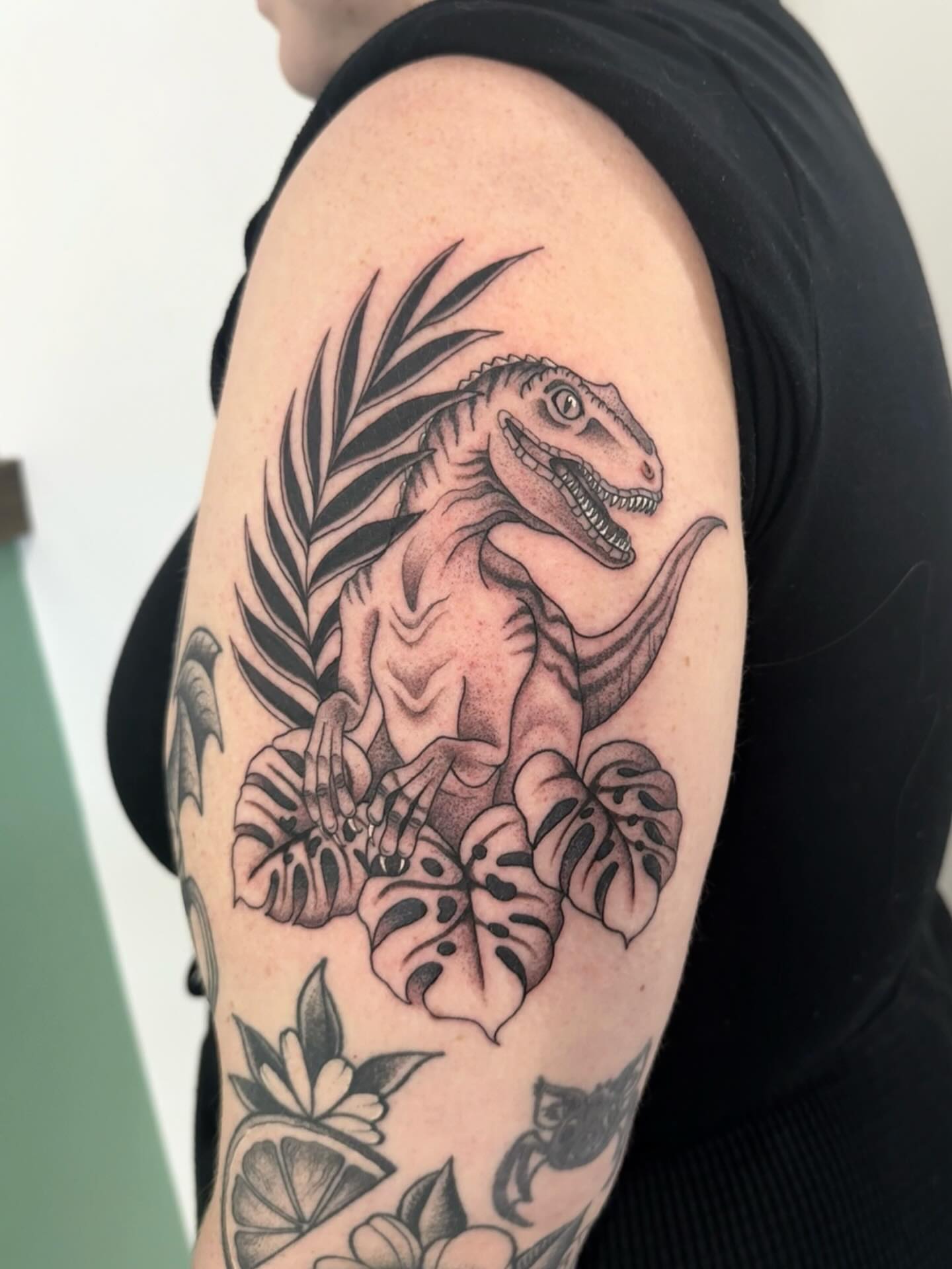 Dinosaur and leaves black and grey tattoo on the forearm by Sierra Hiddleson- Phoenix Arizona Tattoo