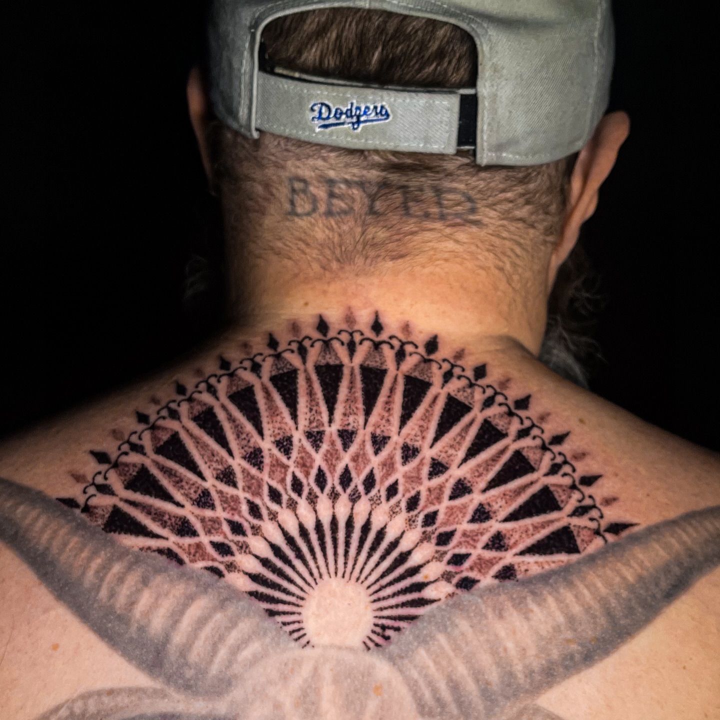 Sunburst geometric tattoo on the back by Miguel Henrik