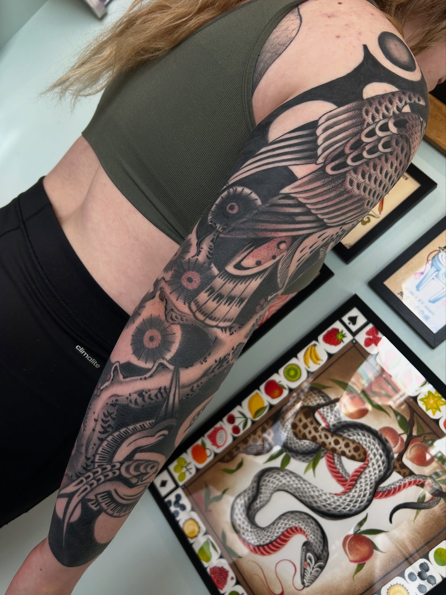 Snake and peony American traditional tattoo on the upper arm by Lilly Binns