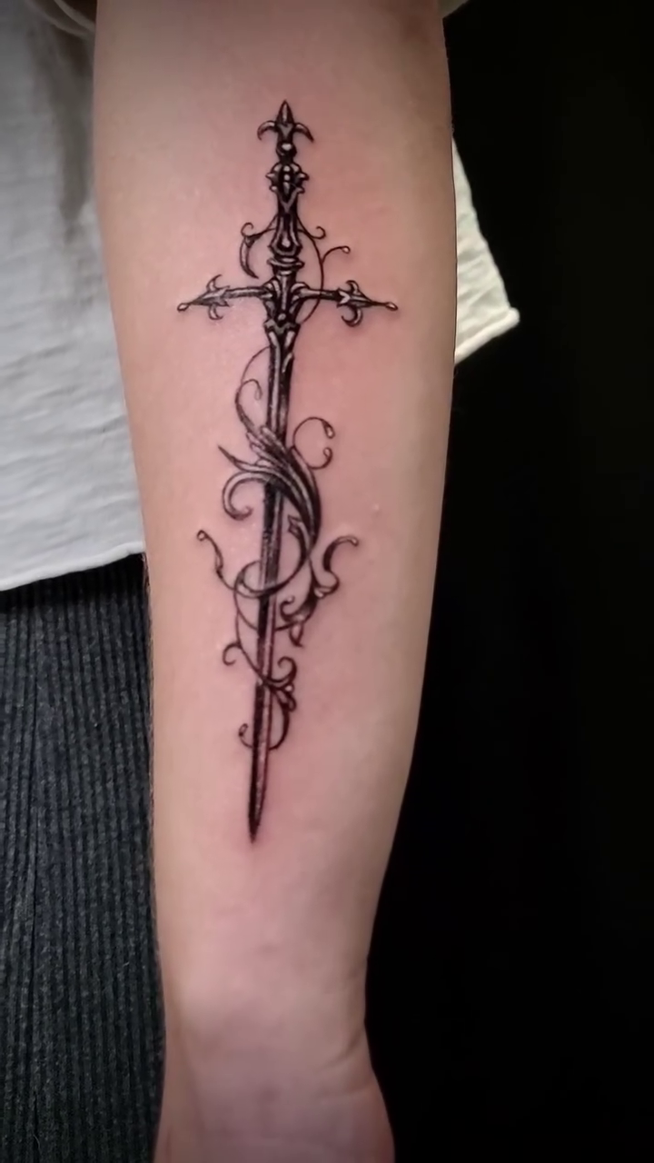 Sword with ornate vine wrap cyber sigilism tattoo on the forearm by William Gualteros