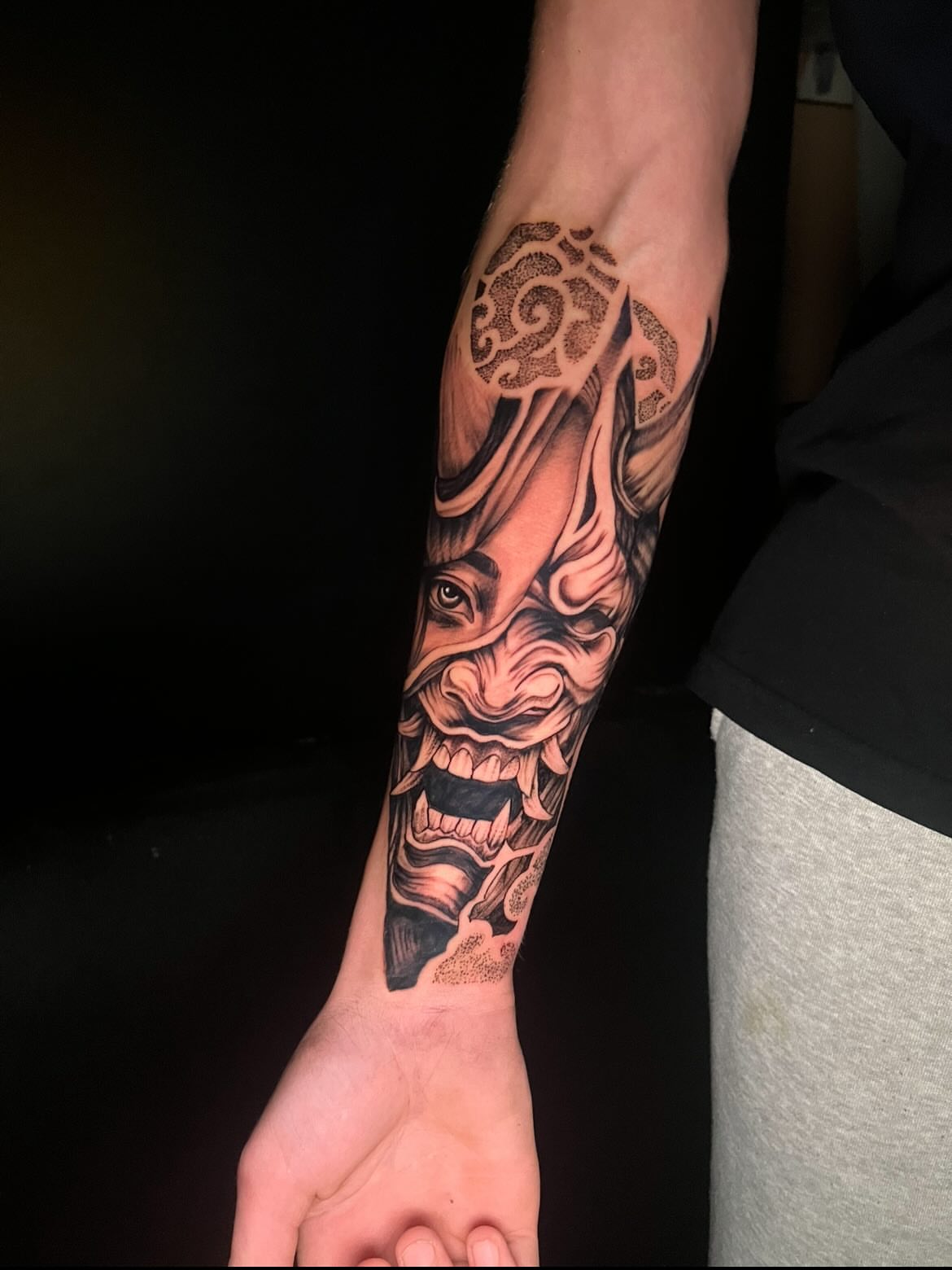 Demon mask dotwork tattoo on the forearm by Deville Pinson