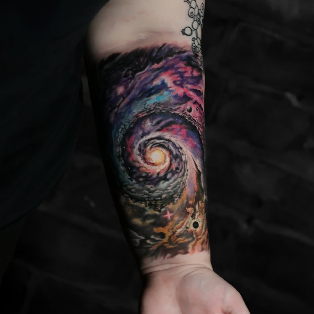 Spiral galaxy with planets surrealism tattoo on the forearm by Felipe Andrade
