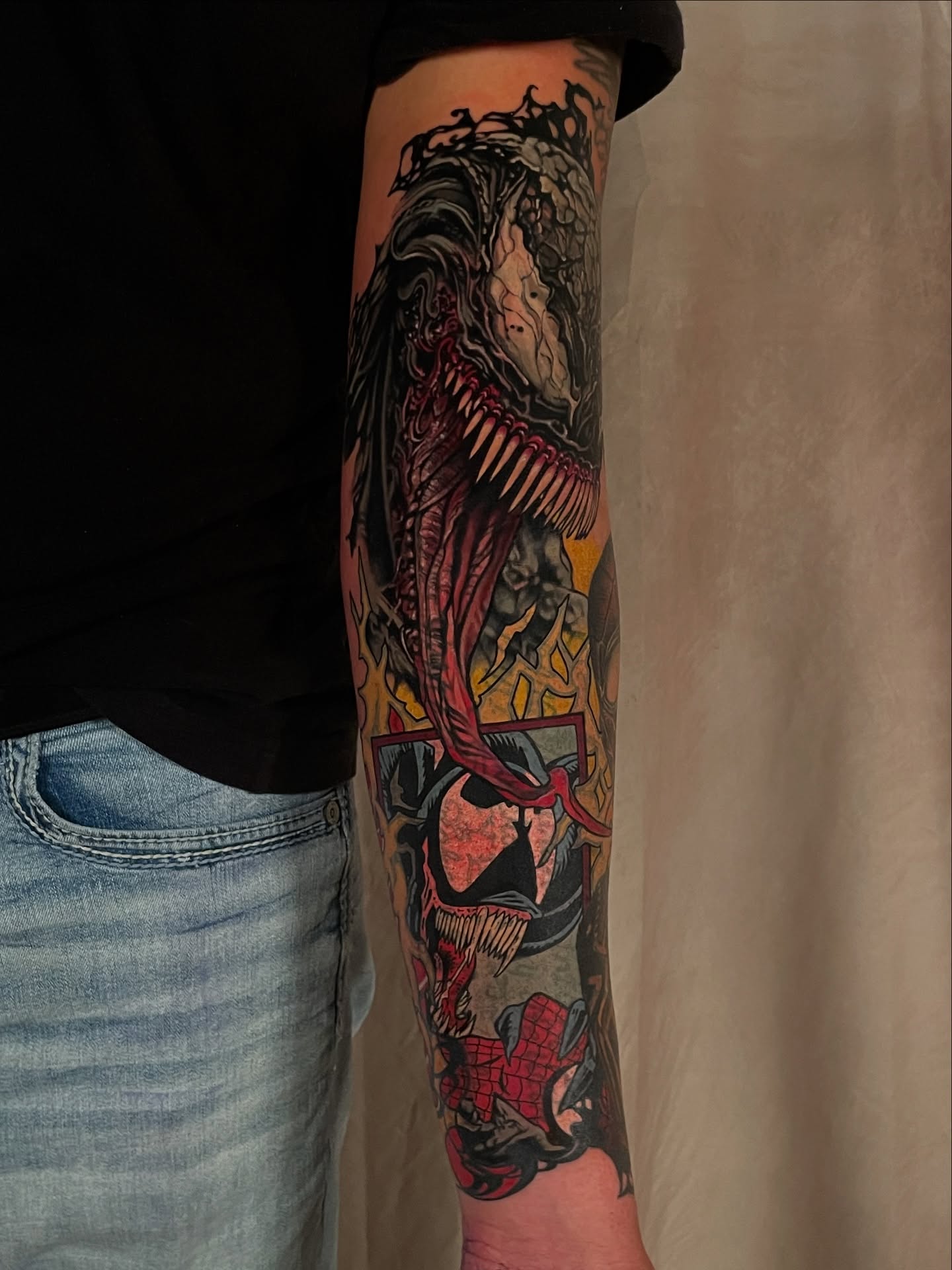 Venom dark realism tattoo on the forearm by <