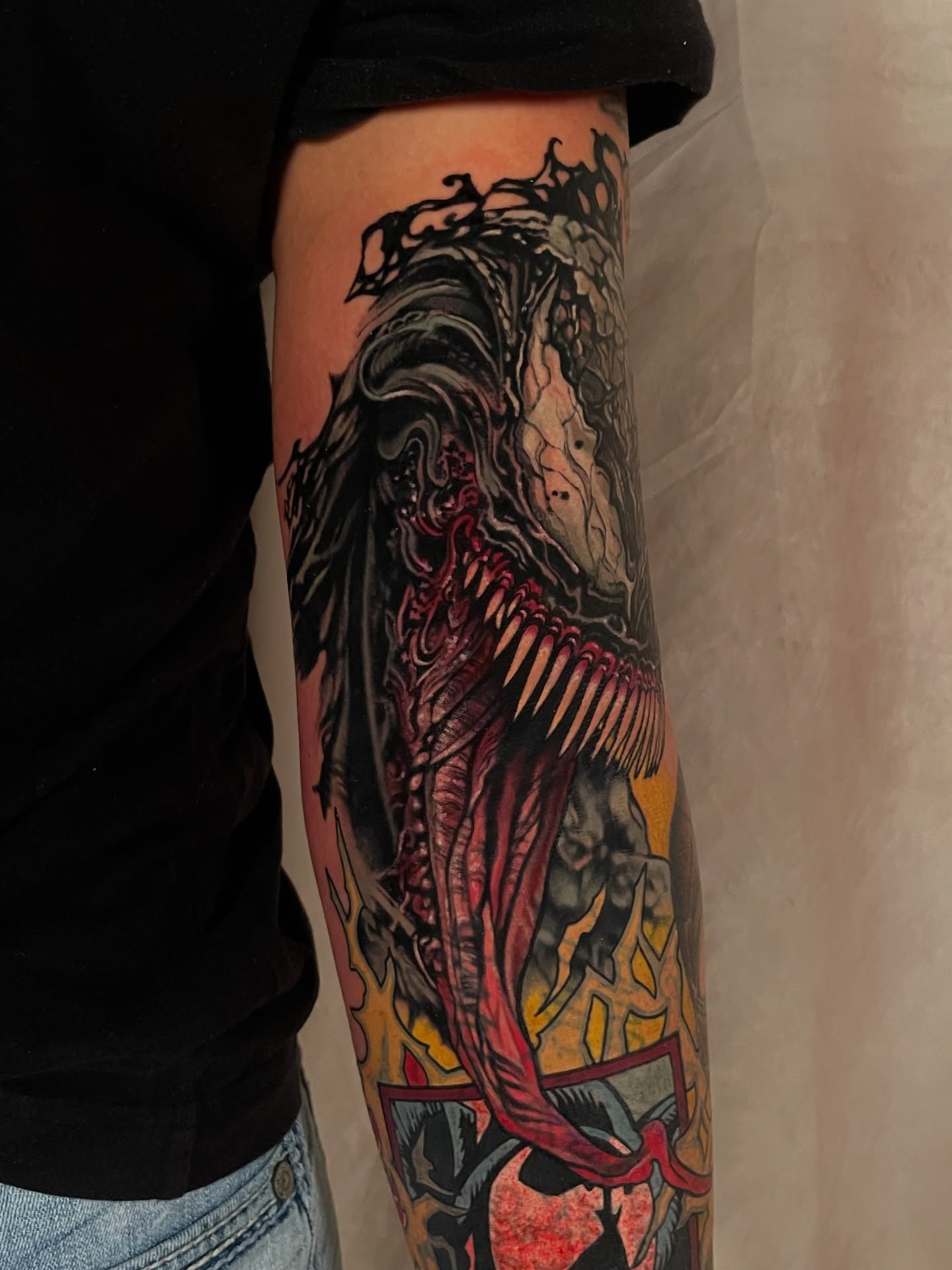 Venom dark realism tattoo on the forearm by <