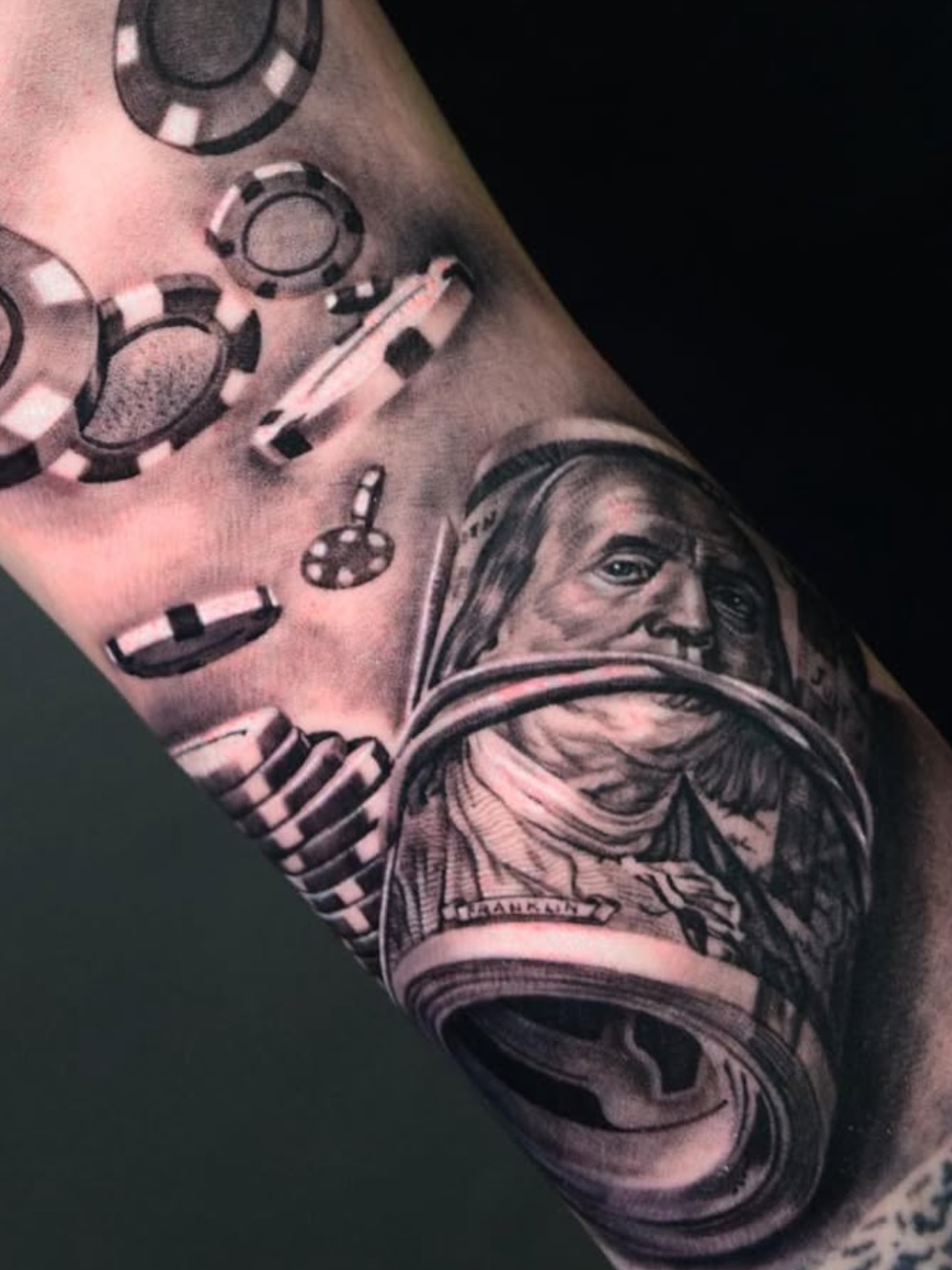 Money and poker chips realism tattoo on the forearm by Sergio Mendez