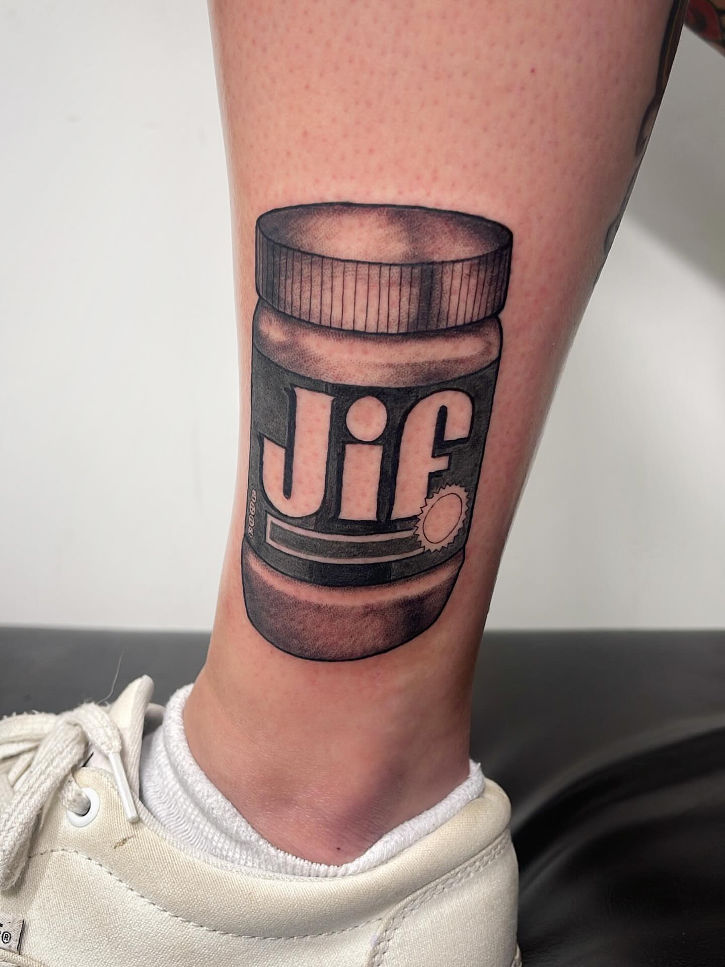 Jif peanut butter jar realism tattoo on the calf by Miesha Busker