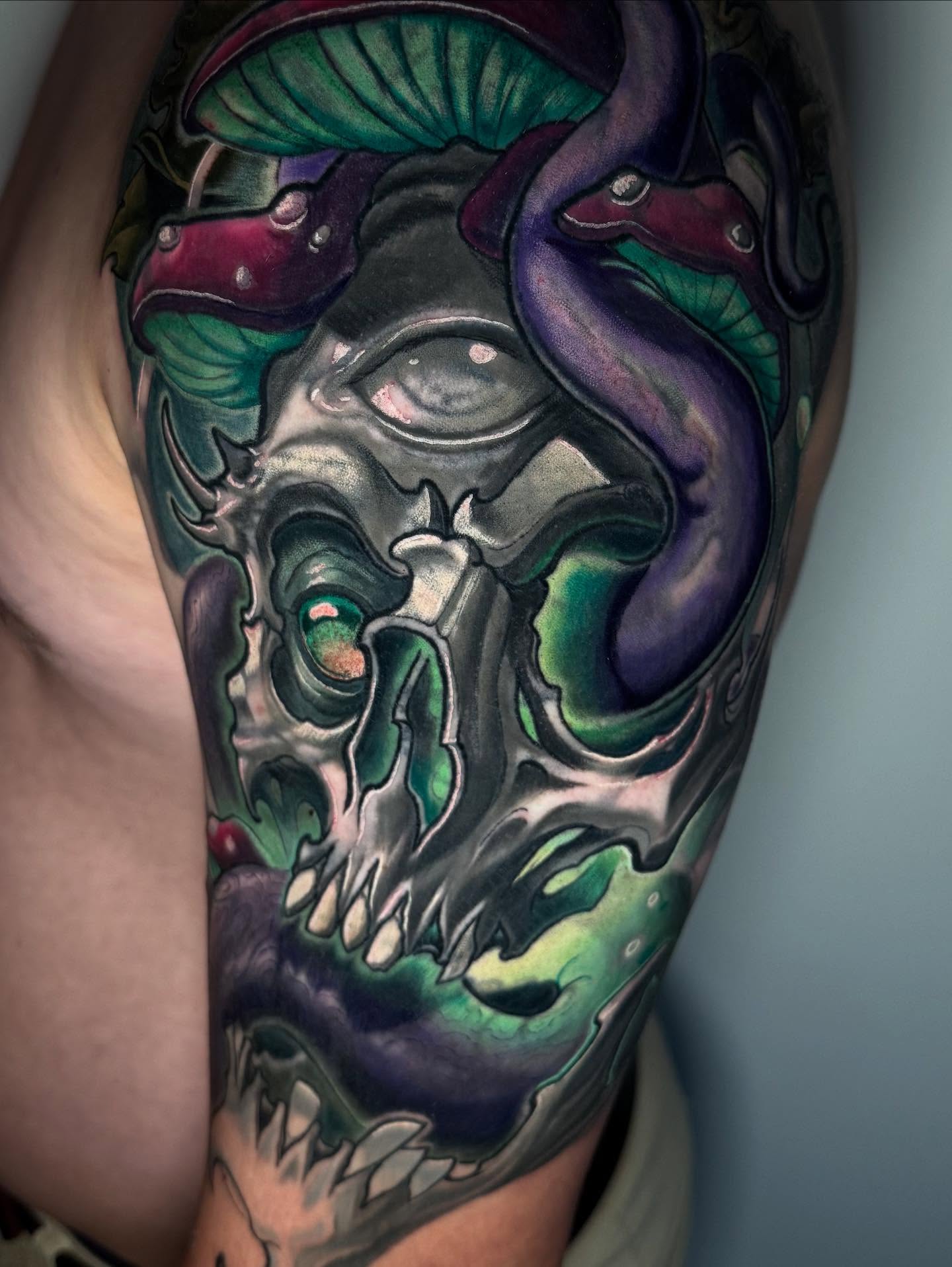 Skull with mushrooms dark realism tattoo on the upper arm by Zoe "Z" Fisk