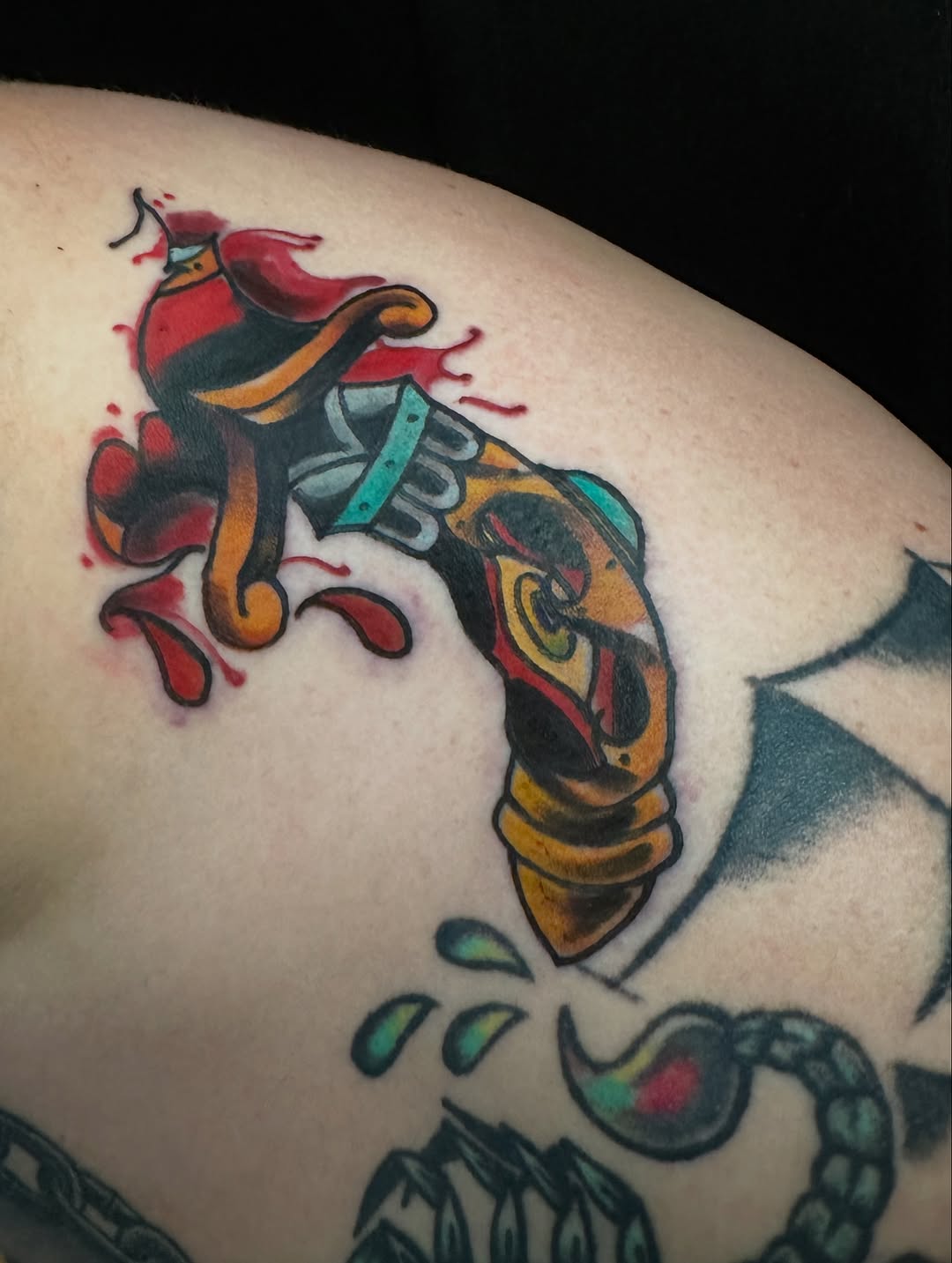 Gun with blood splatter American traditional tattoo on the shoulder by vannadoestattoos
