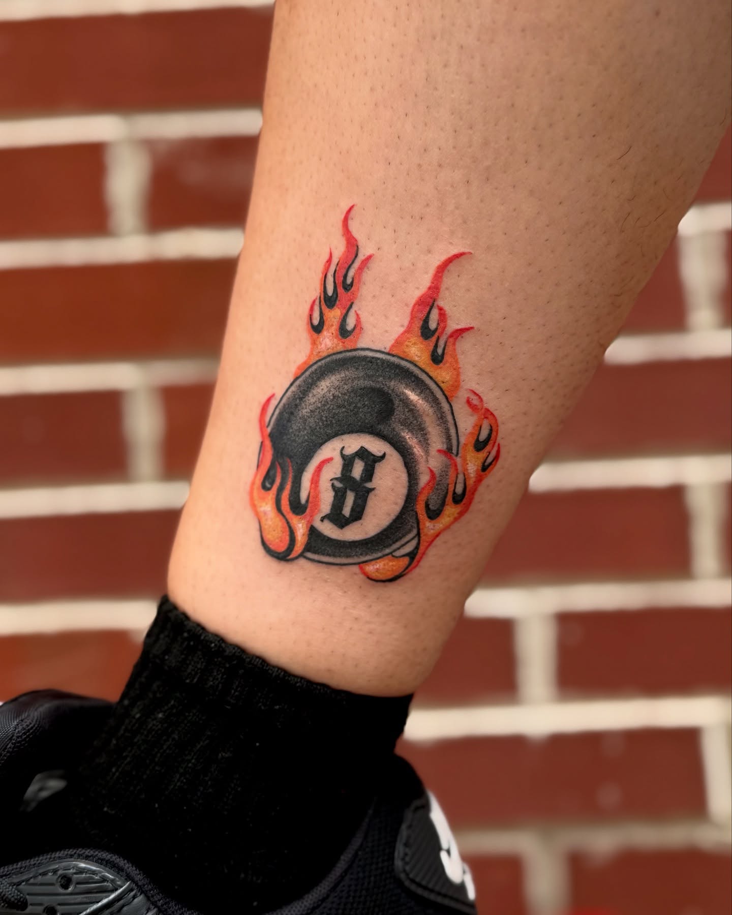 Flaming eight ball American traditional tattoo on the forearm by laura baldwin