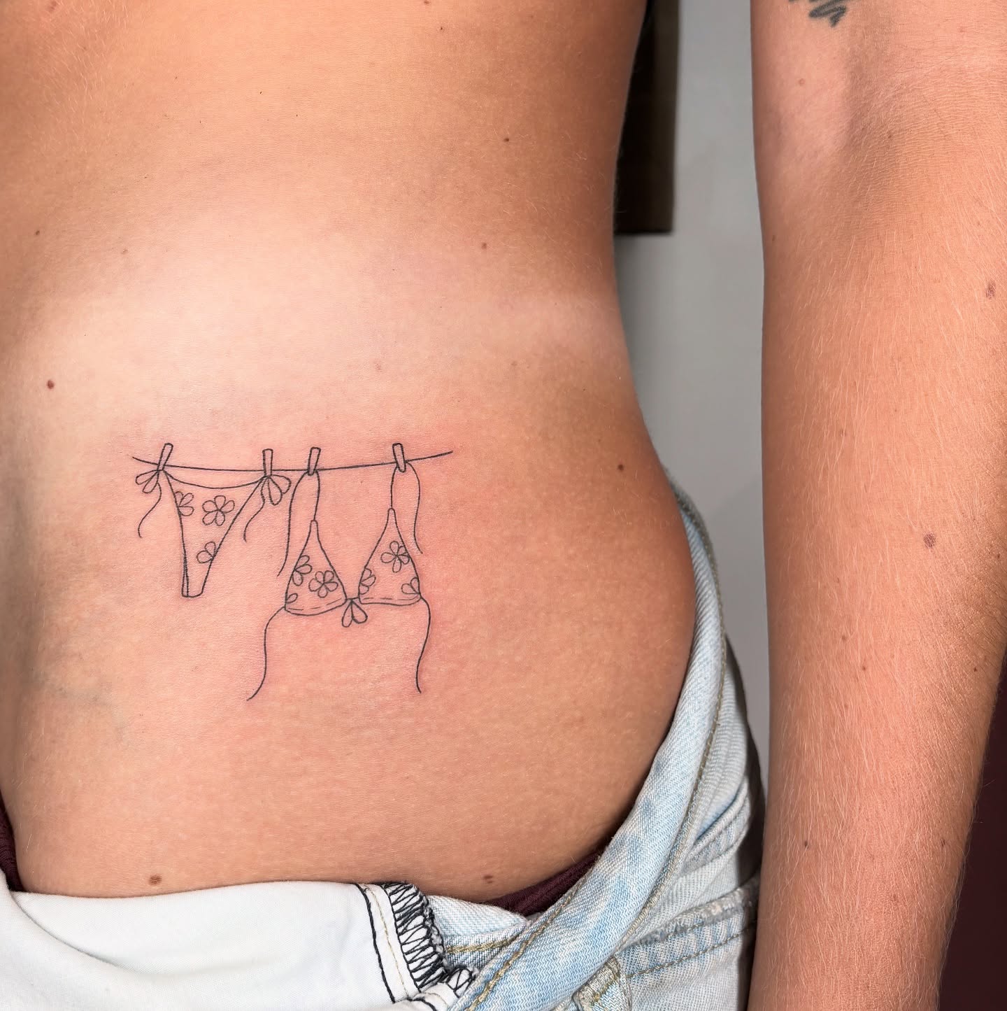 Bra line minimalist tattoo on the ribs by Fineline tattoos by Kinsey