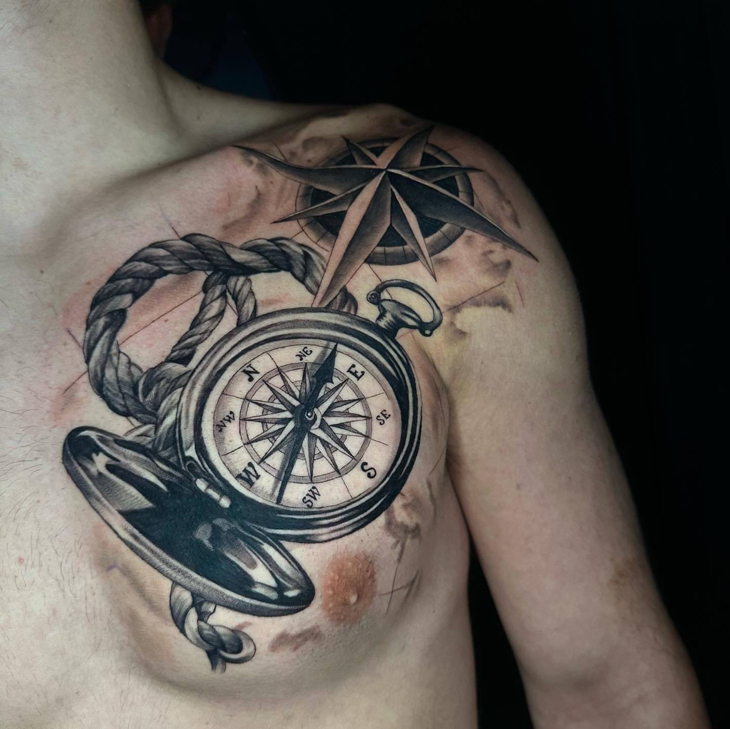Compass and rope black and grey tattoo on the chest by Angela Azure