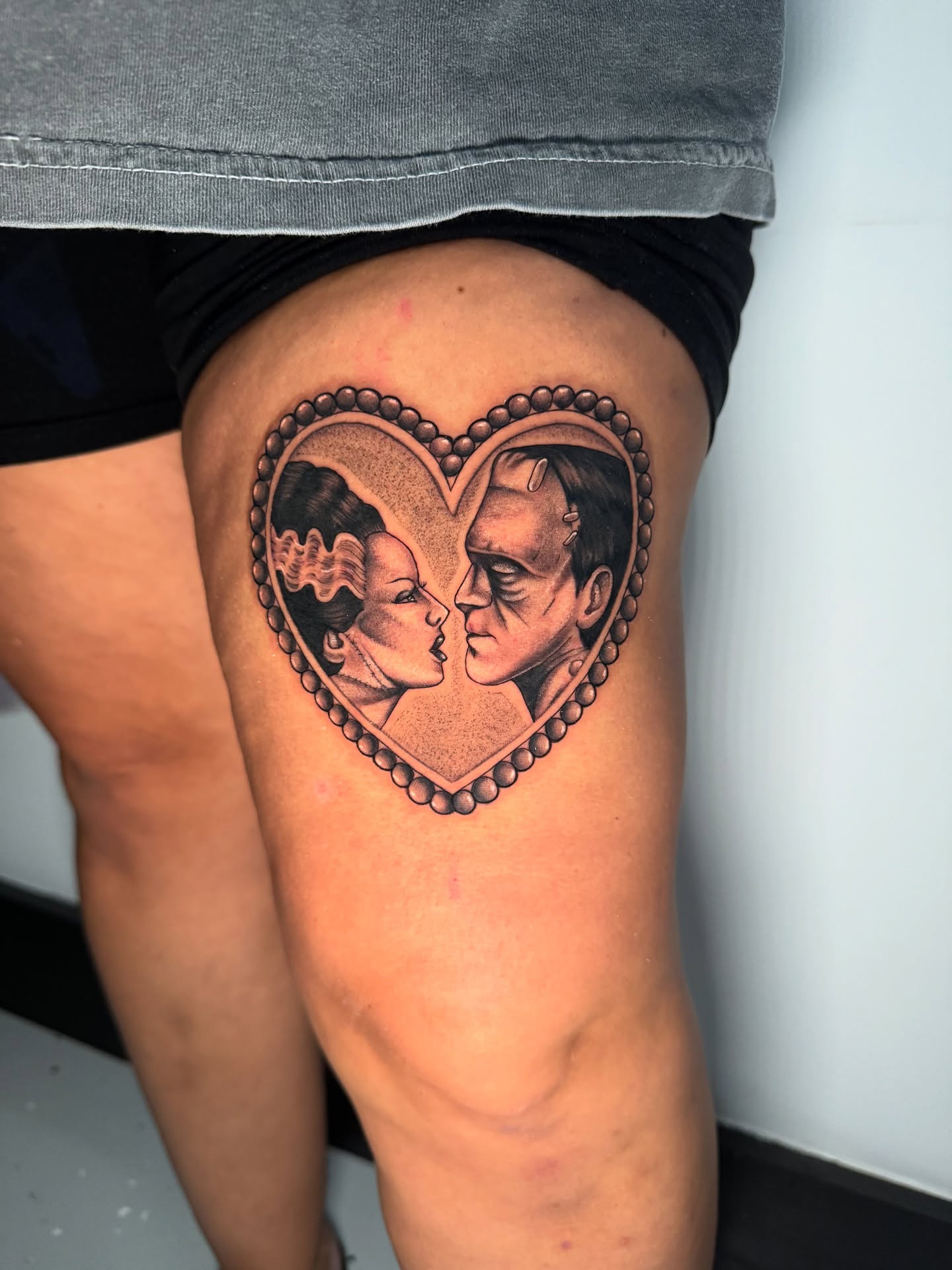 Heart with faces realism tattoo on the thigh by 𝕸𝖔𝖓𝖎𝖖𝖚𝖊𝖊𝖓