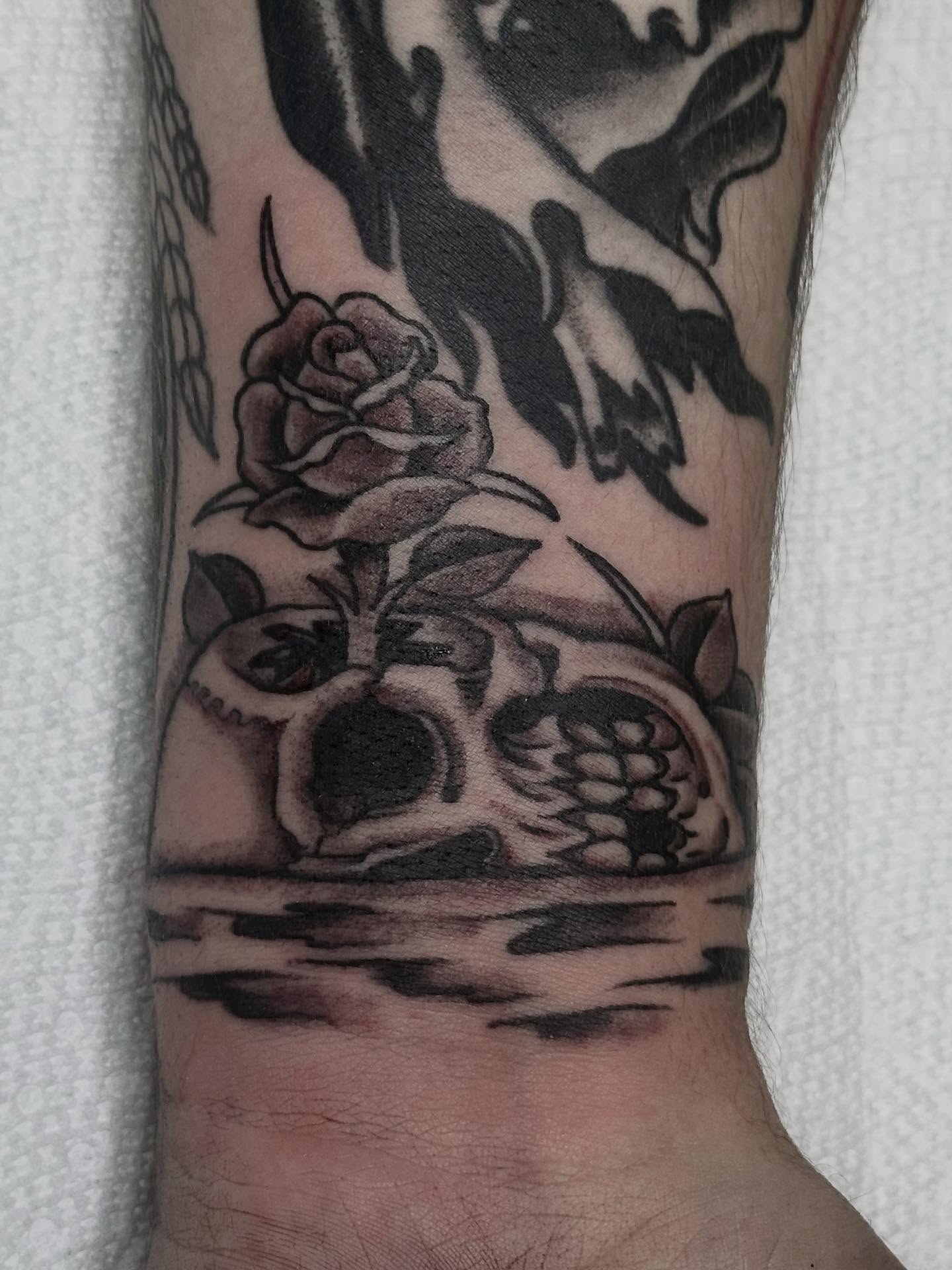Skull and rose black and grey tattoo on the forearm by Jordan Rubin, Dunedin, Florida