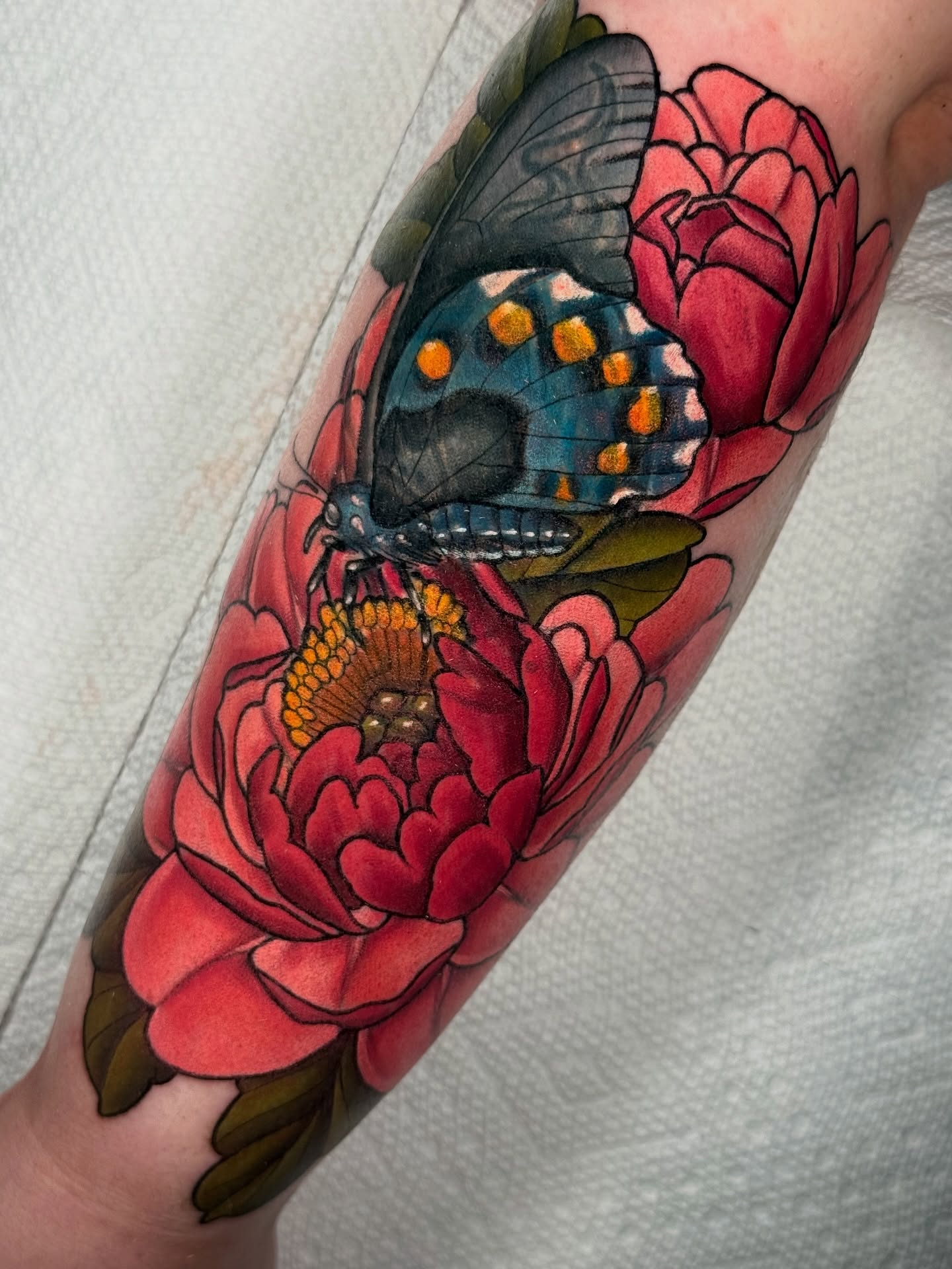 Butterfly and flowers realism tattoo on the forearm by Kyle Kuhn