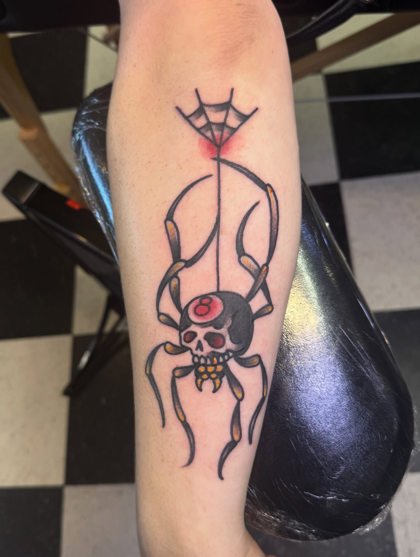 Spider and skull American traditional tattoo on the forearm by Don Robison