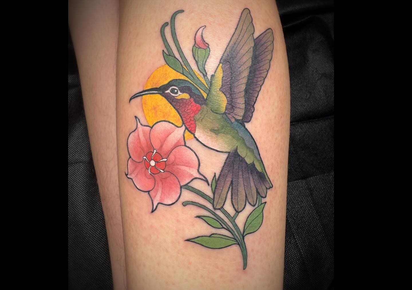 Hummingbird and flower realism tattoo on the thigh by Hannah Casadonti