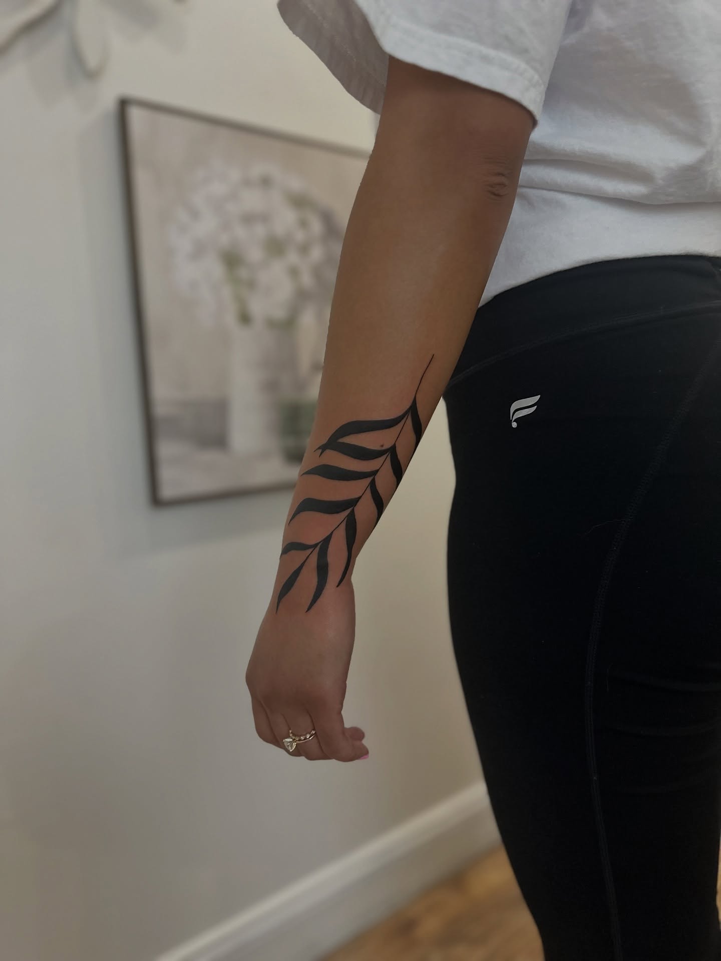 Feather black and grey tattoo on the forearm by Tim Faulkner