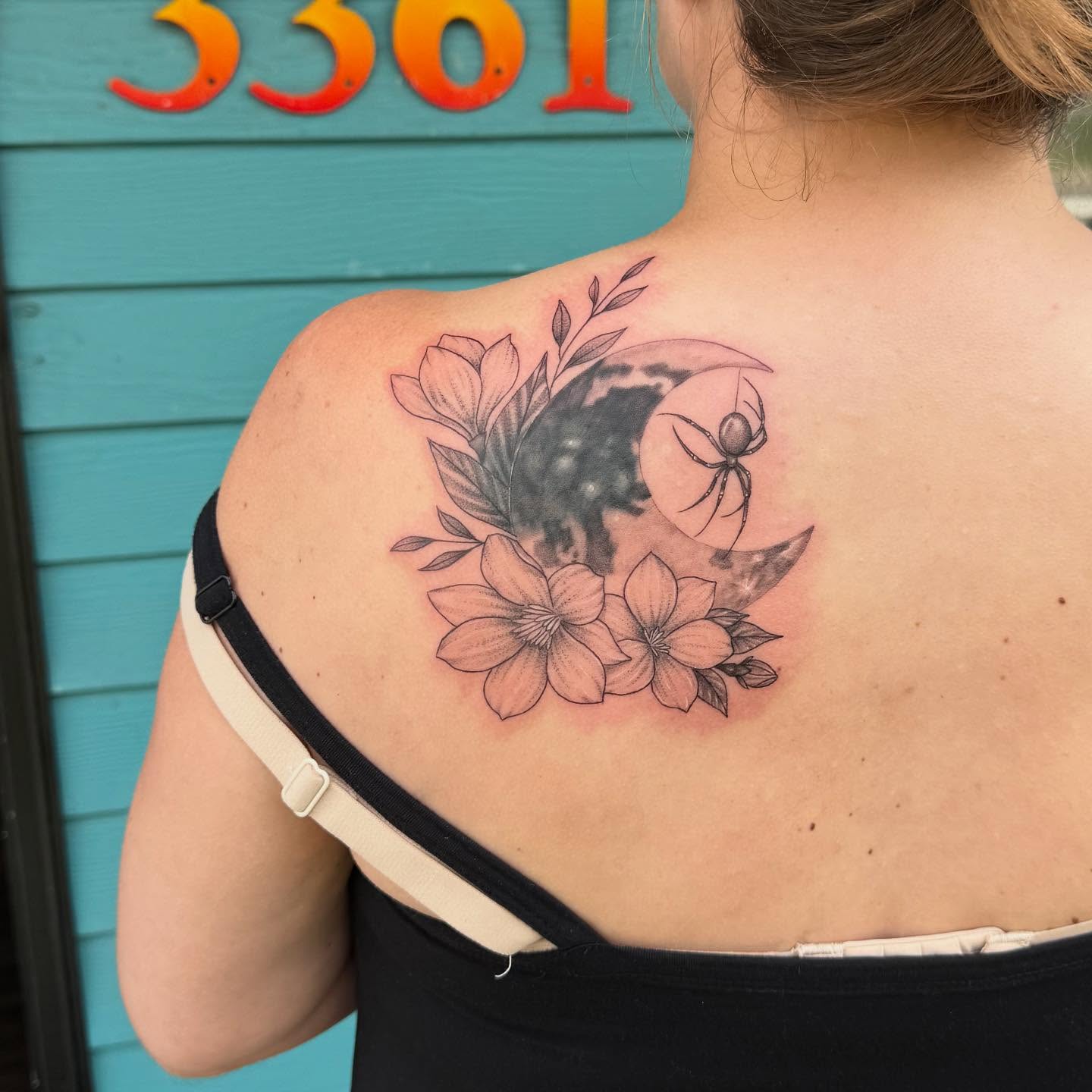 Flowers and crescent moon black and grey tattoo on the shoulder by Leslea Hipp