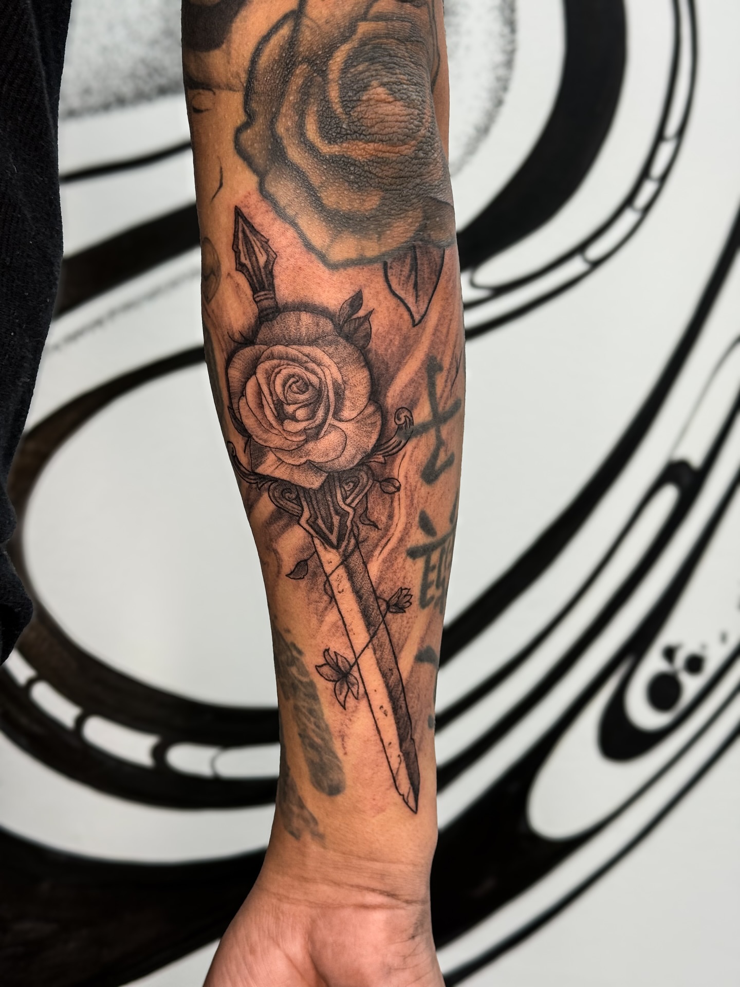 Rose and dagger realism tattoo on the forearm by Brows & Tattoos