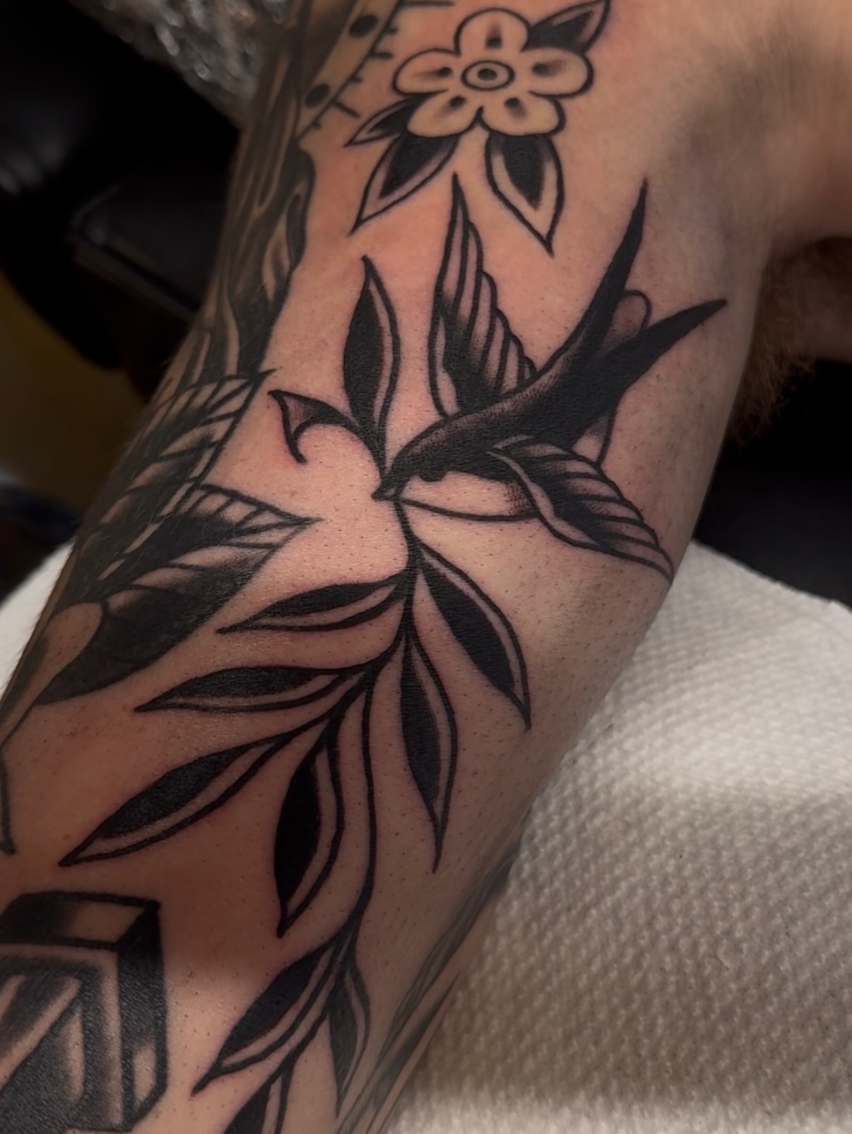 Bird and flower black and grey tattoo on the forearm by Cory Allen
