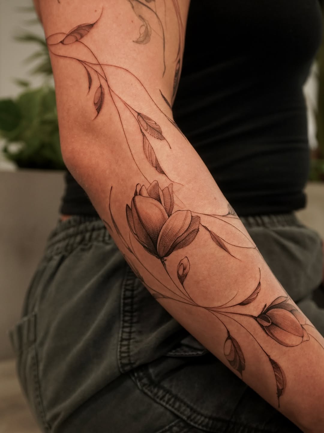 Floral vine with buds fine line tattoo on the forearm by Valentina