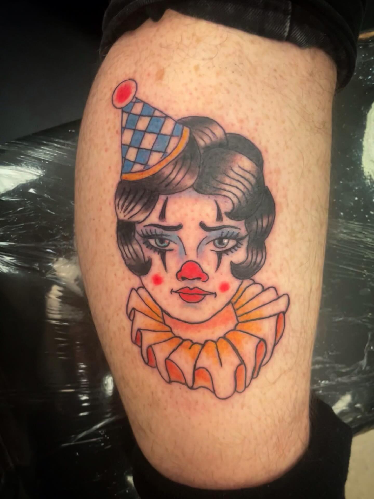 Clown American traditional tattoo on the thigh by Logan Casimir