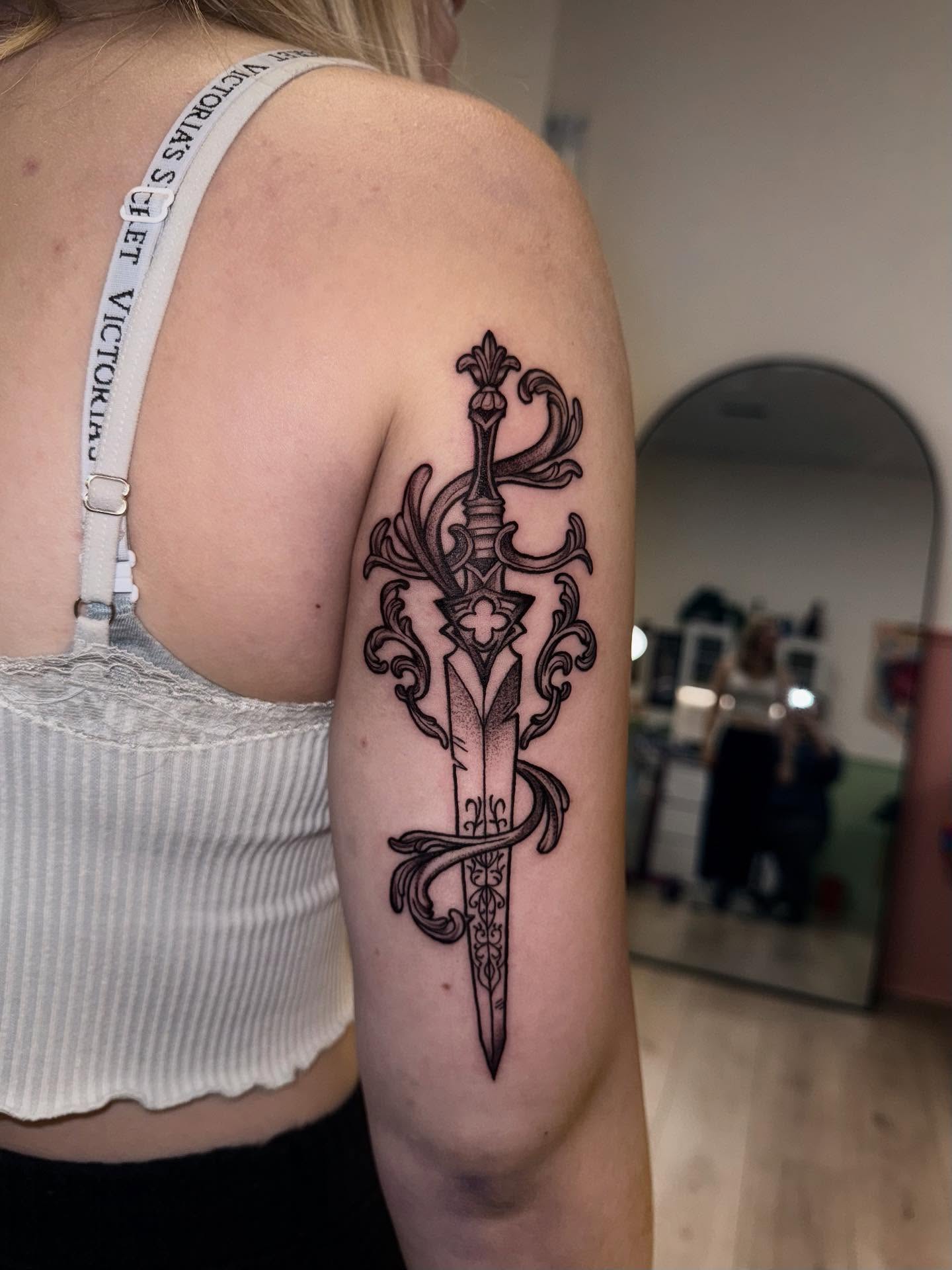 Sword ornamental tattoo on the upper arm by Laurito