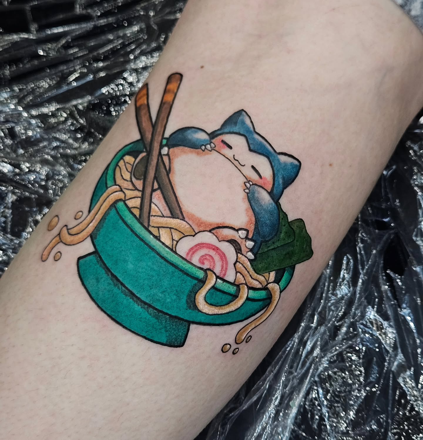 Ramen bowl with cat anime tattoo on the forearm by Kassy Fiori
