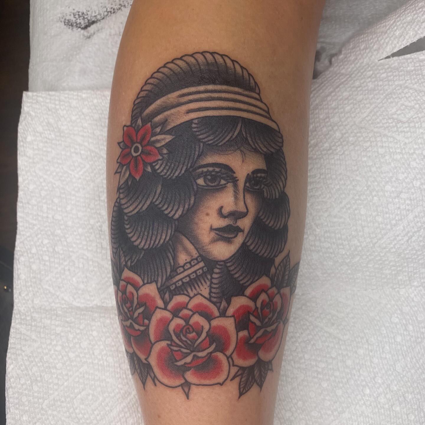 Woman with roses American traditional tattoo on the forearm by Thomas Cook