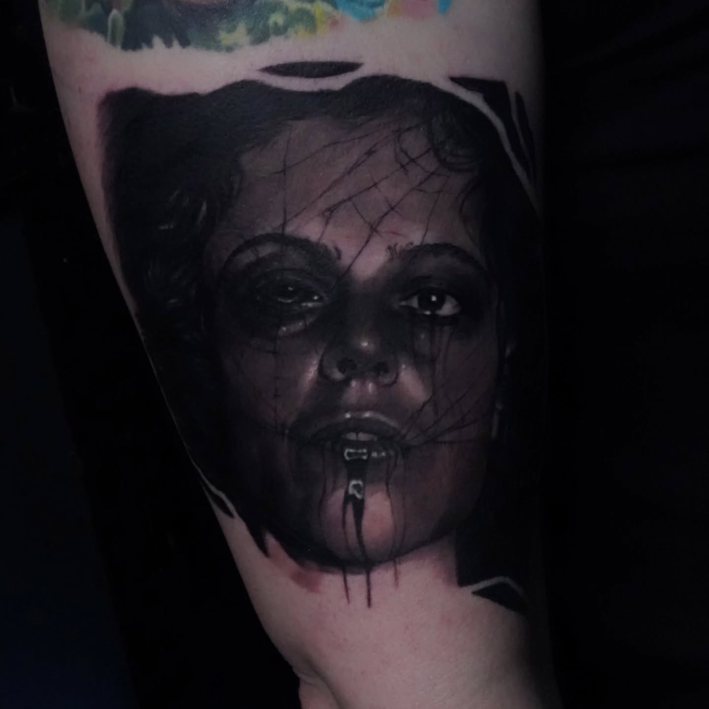 Woman with spiderweb dark realism tattoo on the forearm by Dan Redding