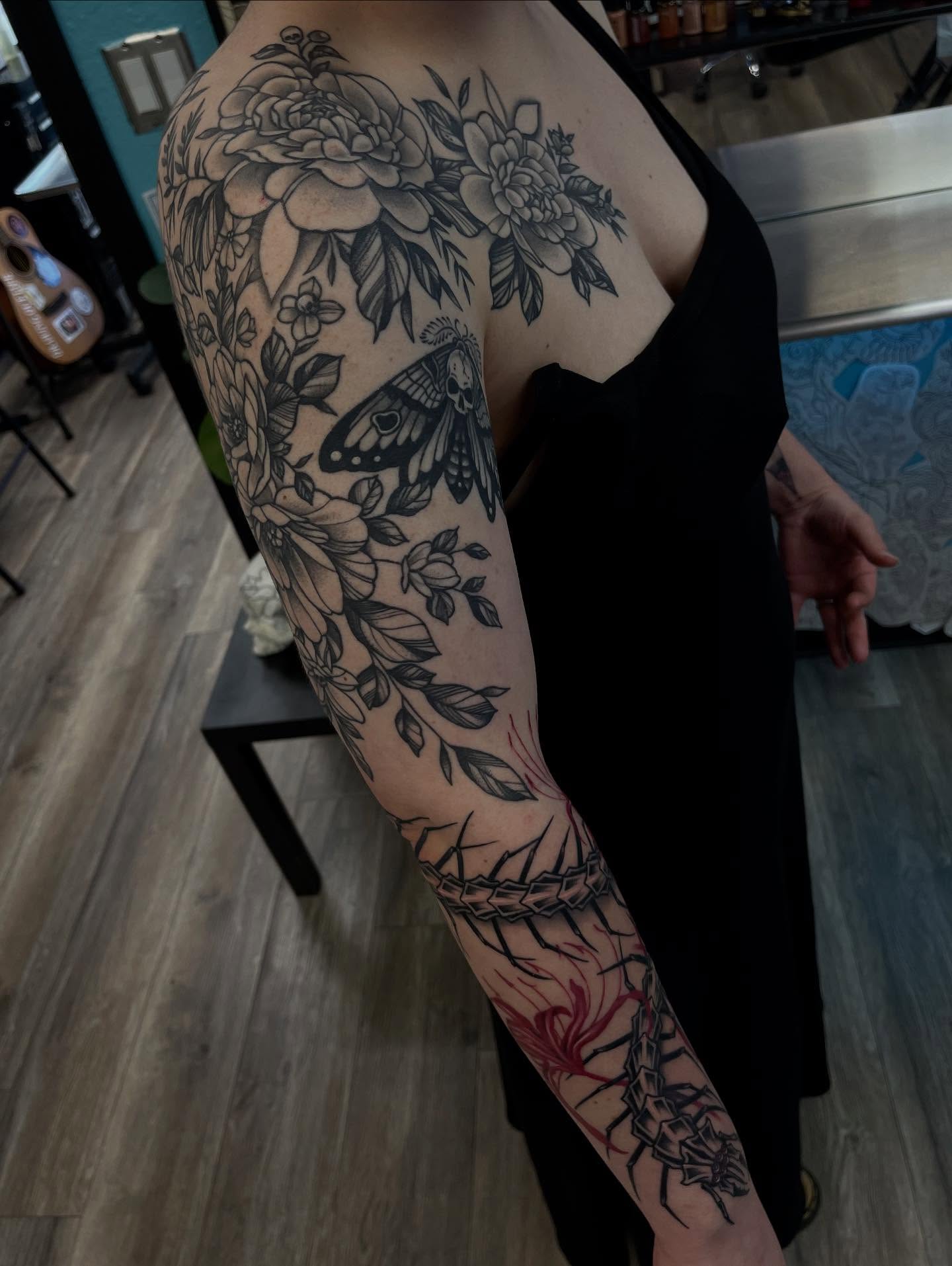 Floral bouquet with butterfly realism tattoo on the upper arm by Sacramento Tattoos (Ilona)