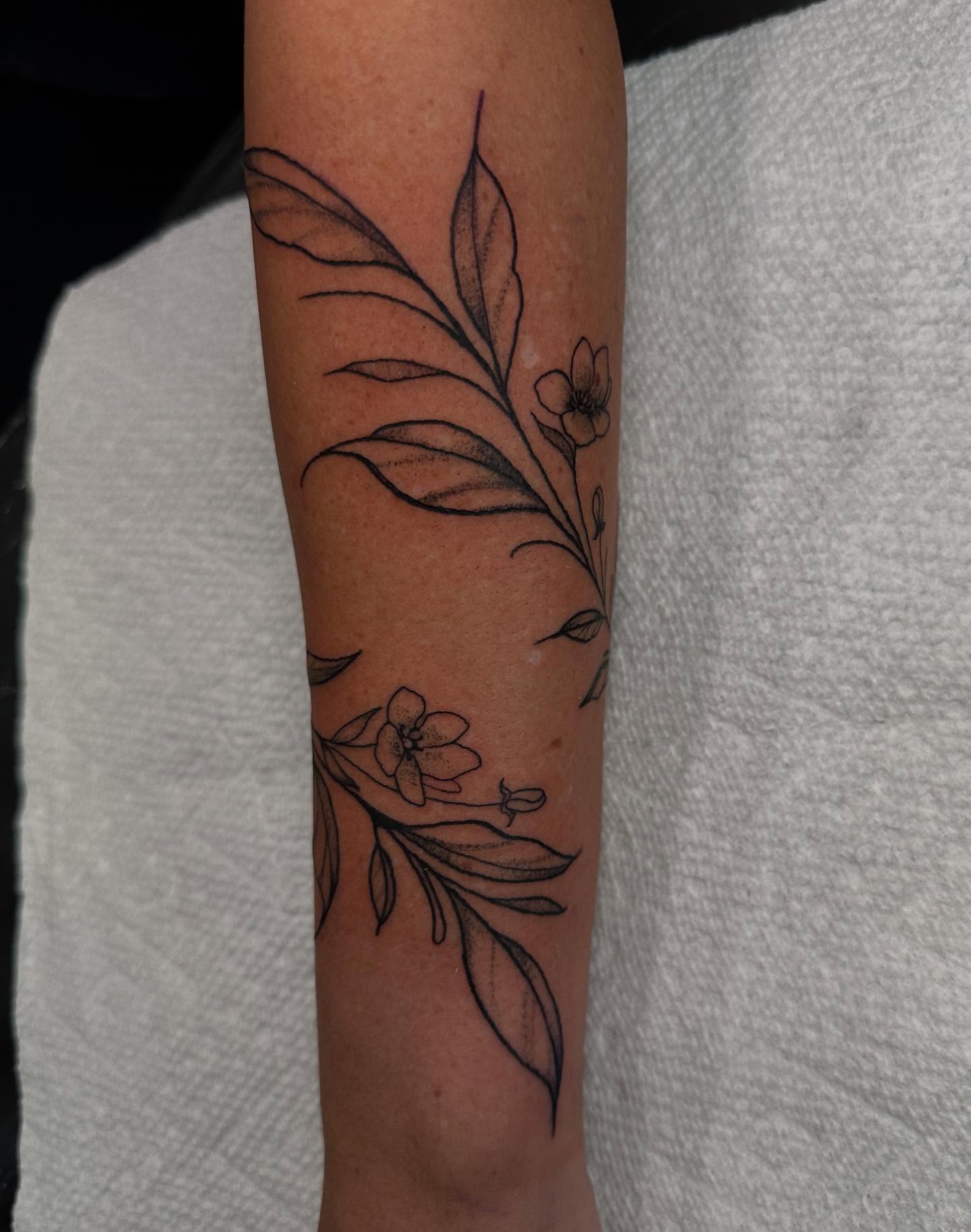 Floral design black and grey tattoo on the forearm by Mika'la Berry
