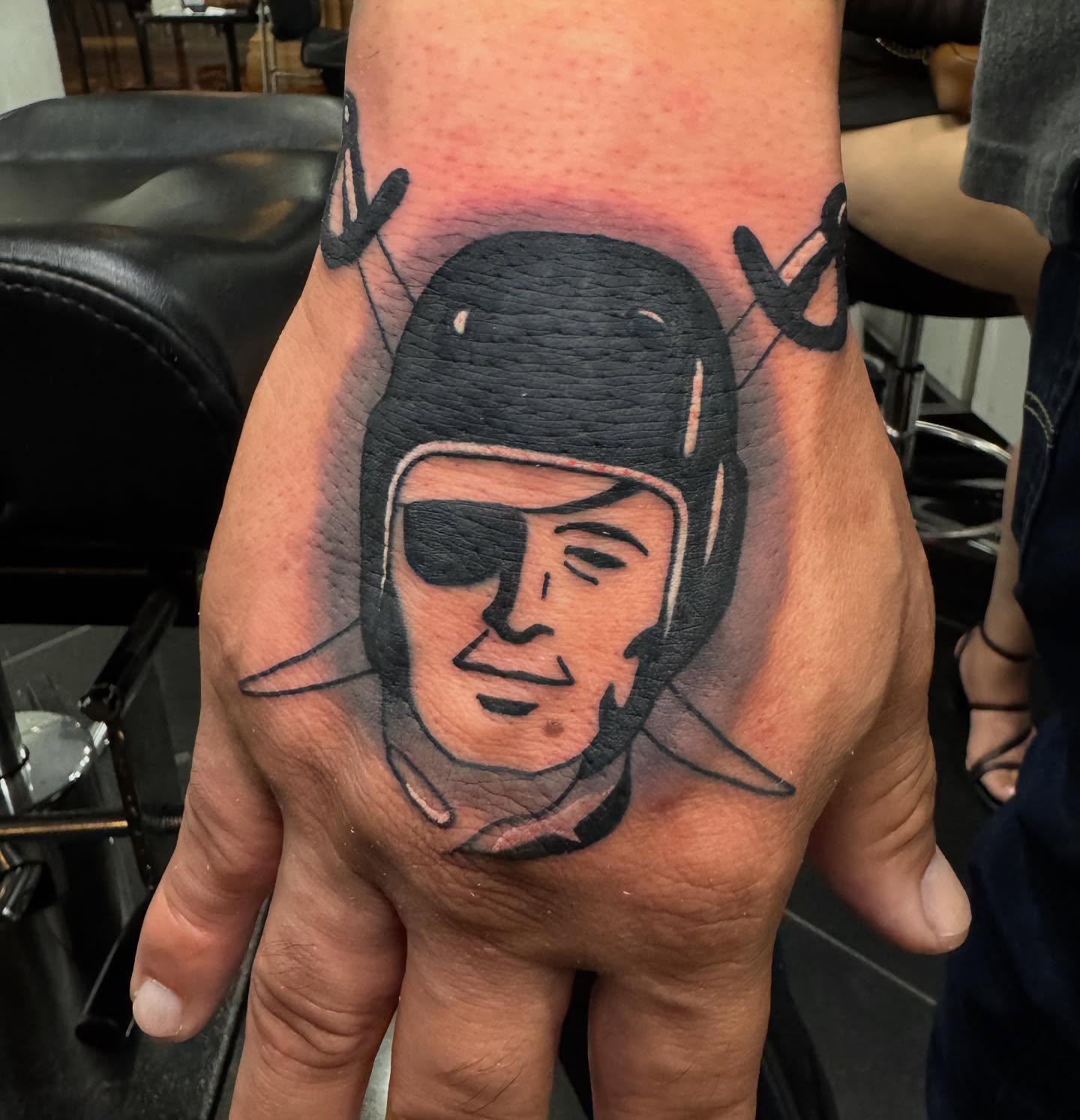 Astronaut helmet black and grey tattoo on the hand by Brian Herrera