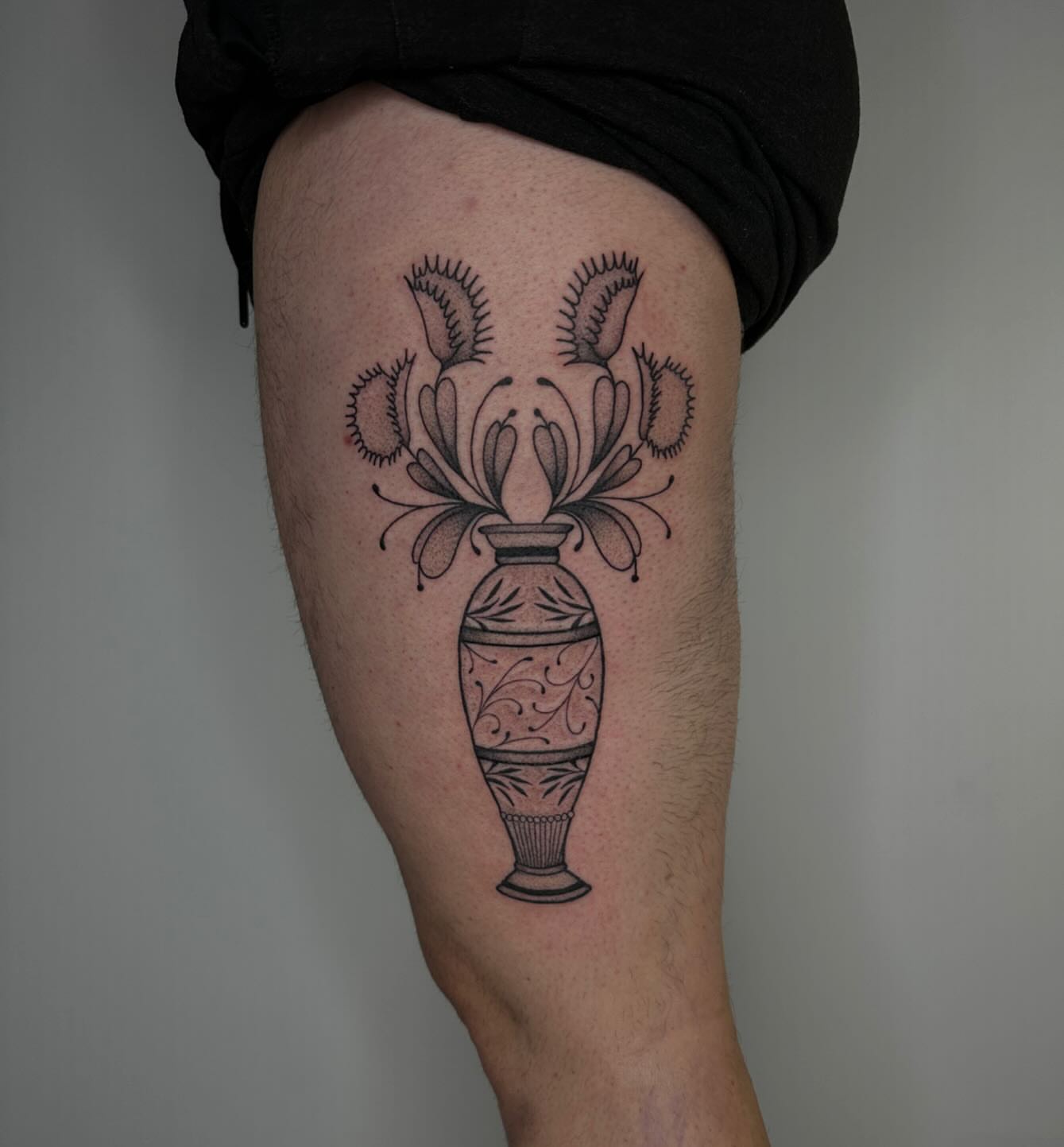 Vase with carnivorous plants black and grey tattoo on the thigh by Erin Shea