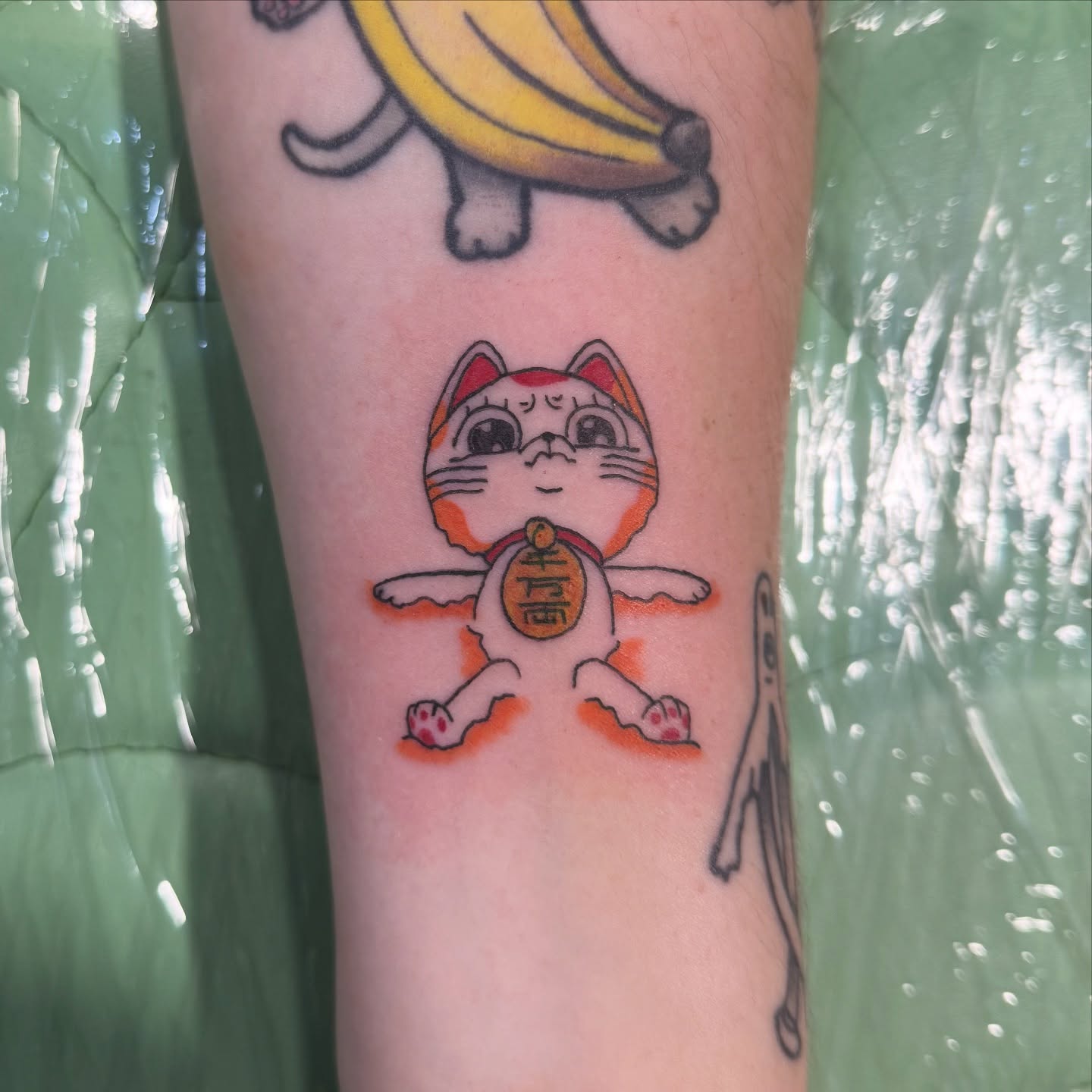 Maneki-neko illustrative tattoo on the forearm by Minxxy Tattoos