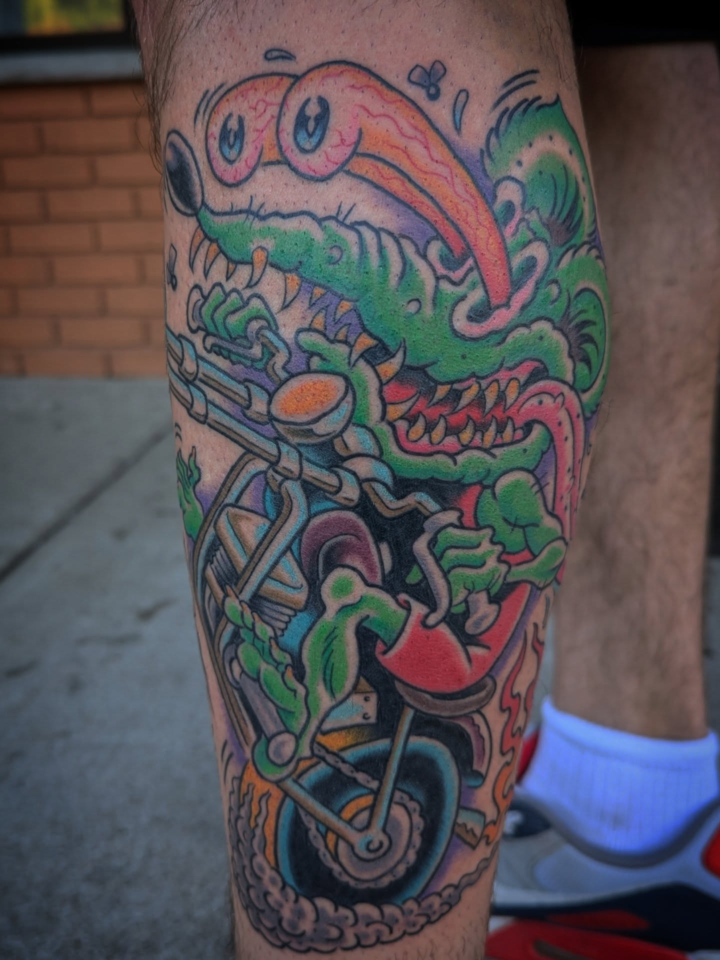 Alien on motorcycle American traditional tattoo on the forearm by Ryan Slegel