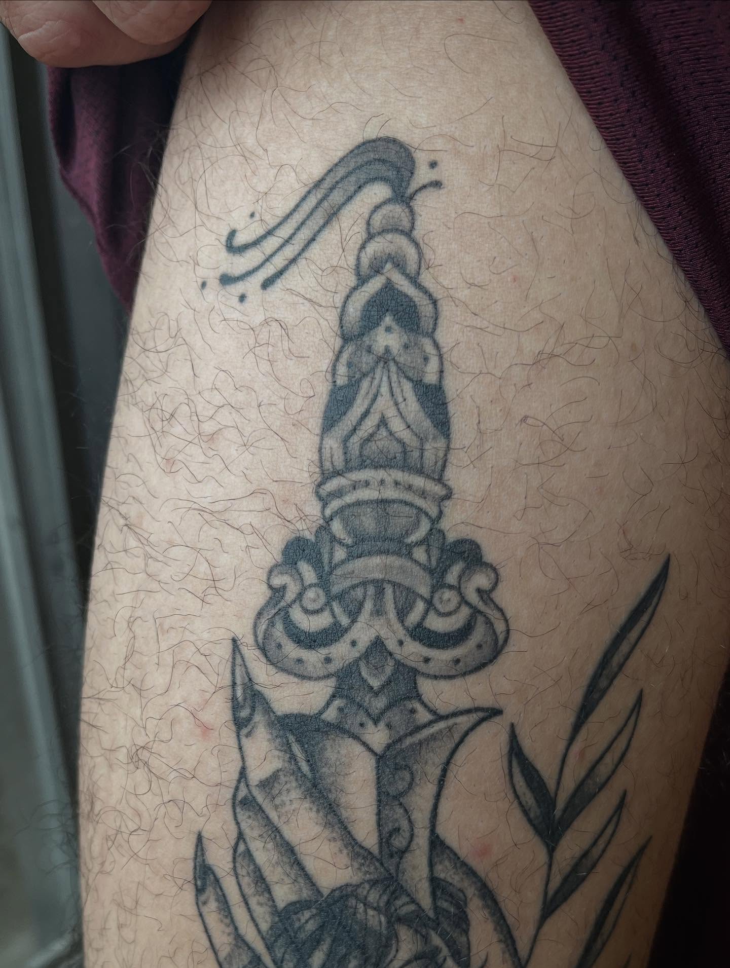 Sword black and grey tattoo on the thigh by Taylor Santavicca