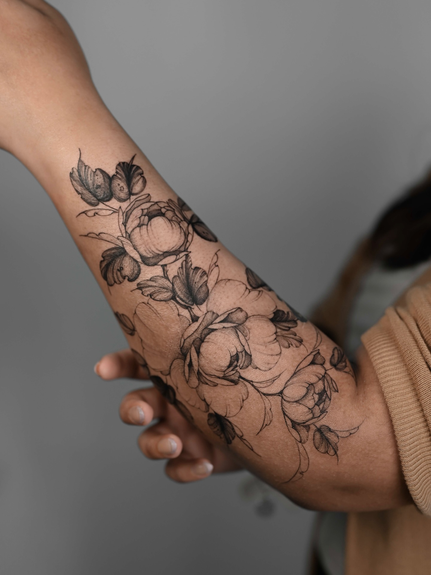 Floral bouquet black and grey tattoo on the forearm by Anastasiia