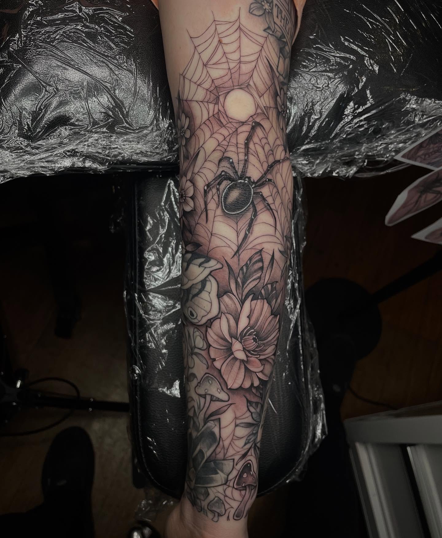 Spider web and flowers realism tattoo on the forearm by Lauren Sisouphanh, Canton, Ohio