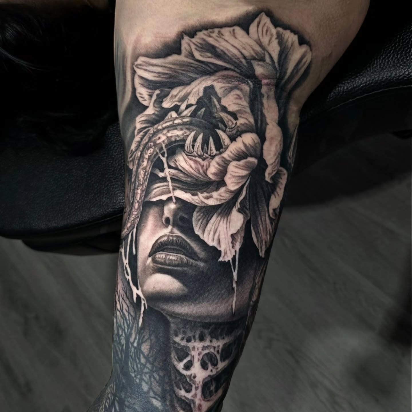 Woman's face with floral elements realism tattoo on the forearm by Julia Oravets