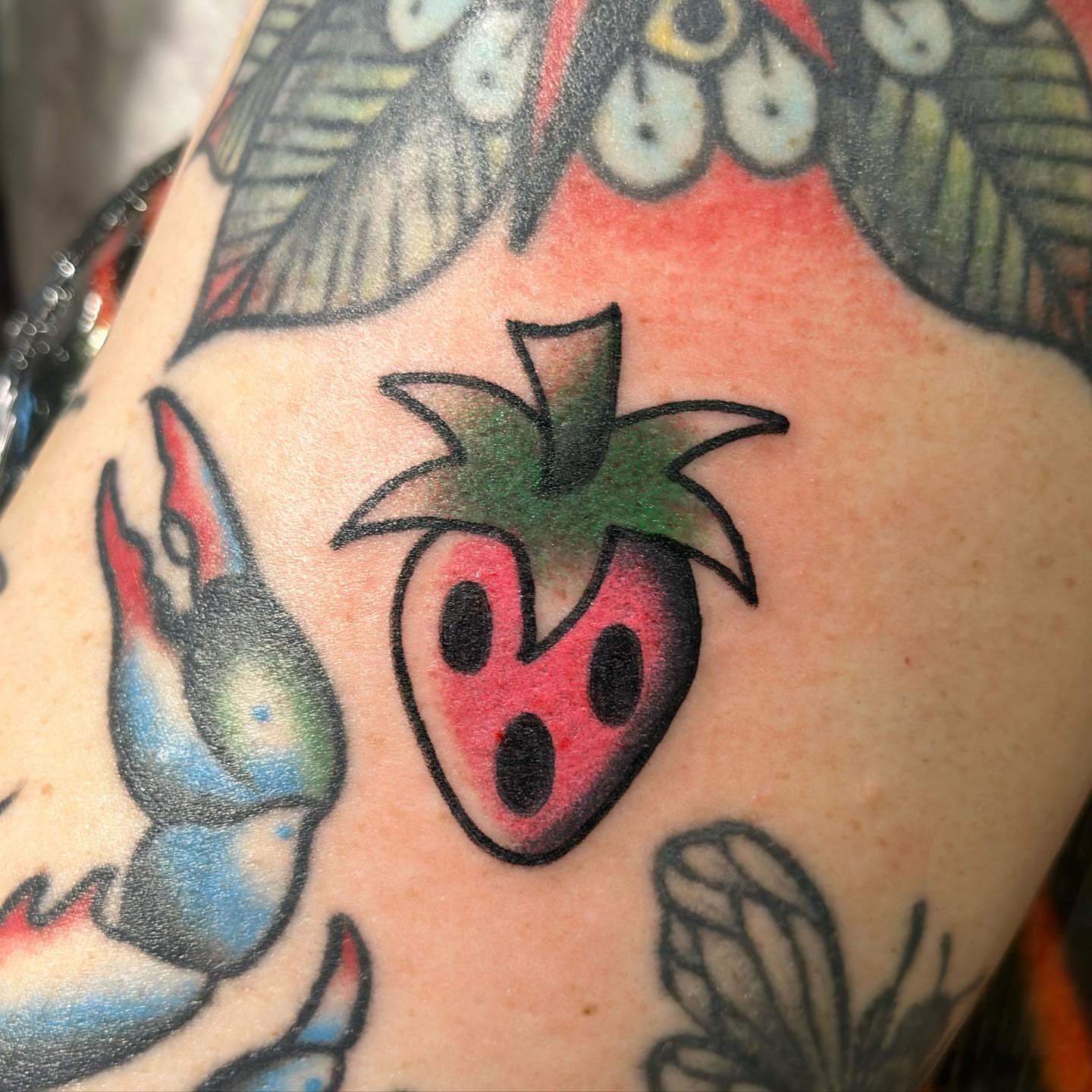 Strawberry American traditional tattoo on the shoulder by Alexa Wolfkiel