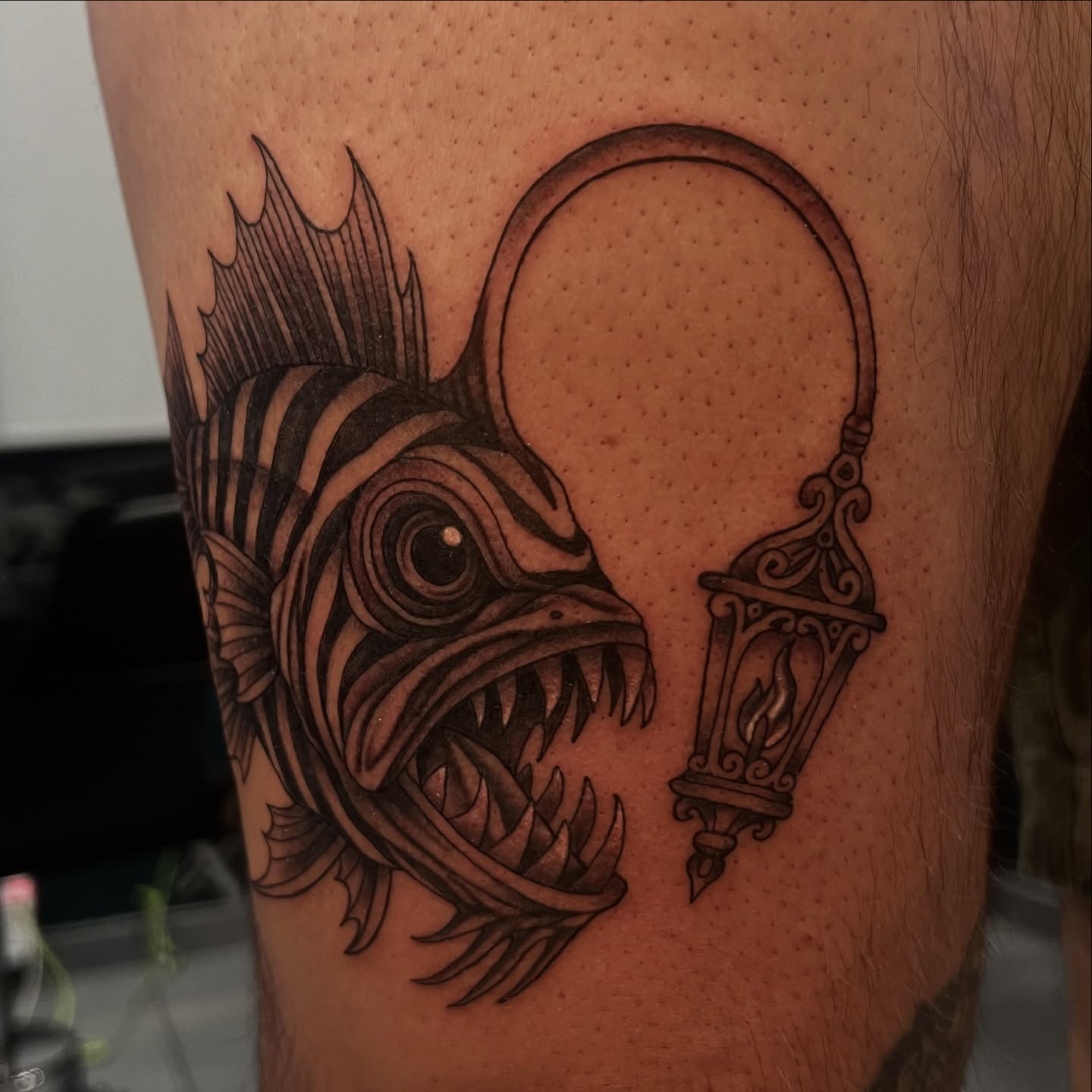 Fish and lantern realism tattoo on the thigh by Nikki Malfitano