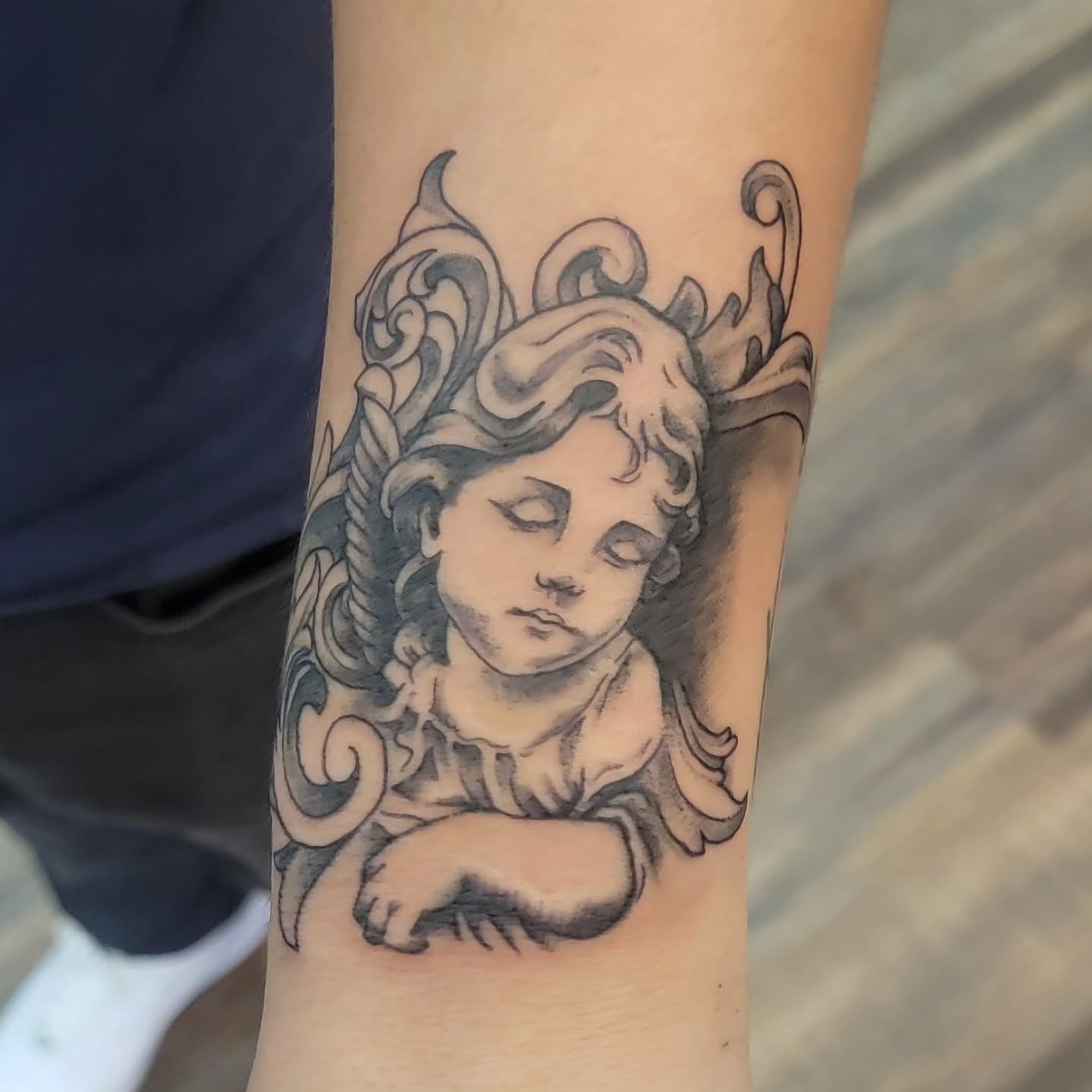 Cherub angel realism tattoo on the forearm by Hatchetfoot Art
