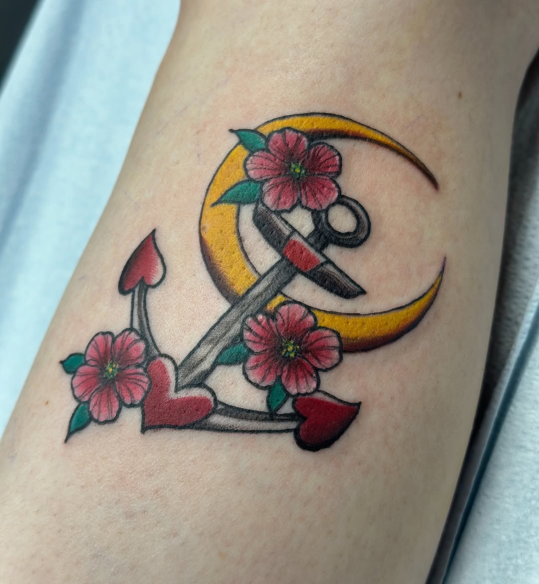 Anchor with moon and flowers American traditional tattoo on the forearm by vannadoestattoos