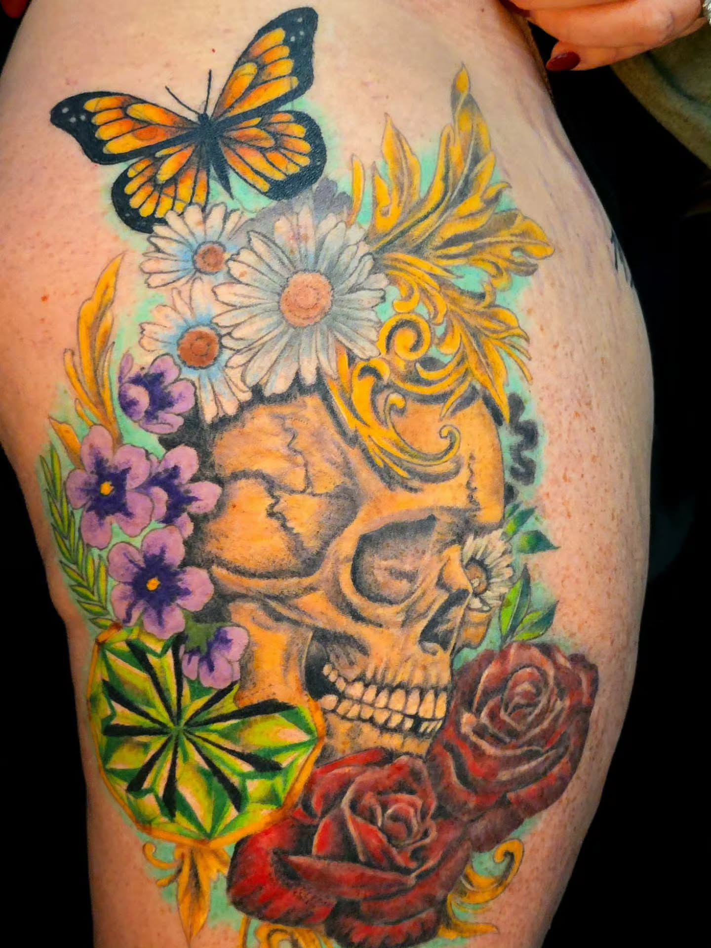 Skull with flowers realism tattoo on the thigh by Karley Michelle Moody