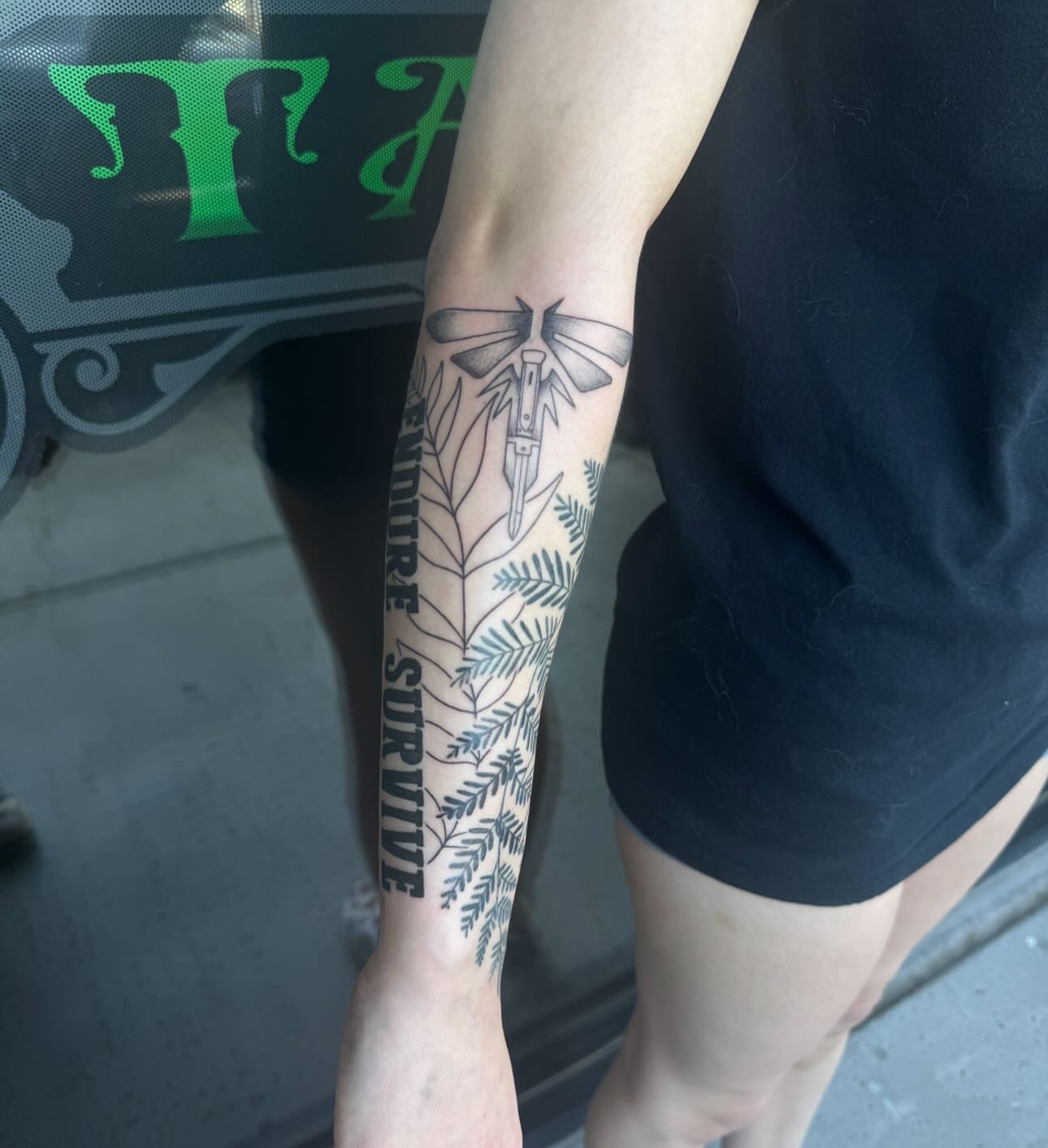 Knife and dragonfly black and grey tattoo on the forearm by Jianna