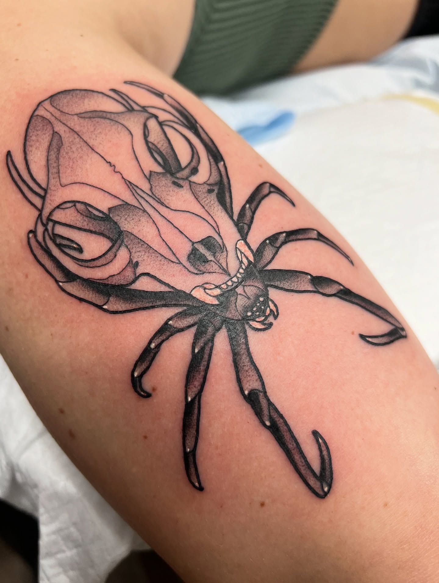 Rose and skull realism tattoo on the upper arm by Nathan Garcia